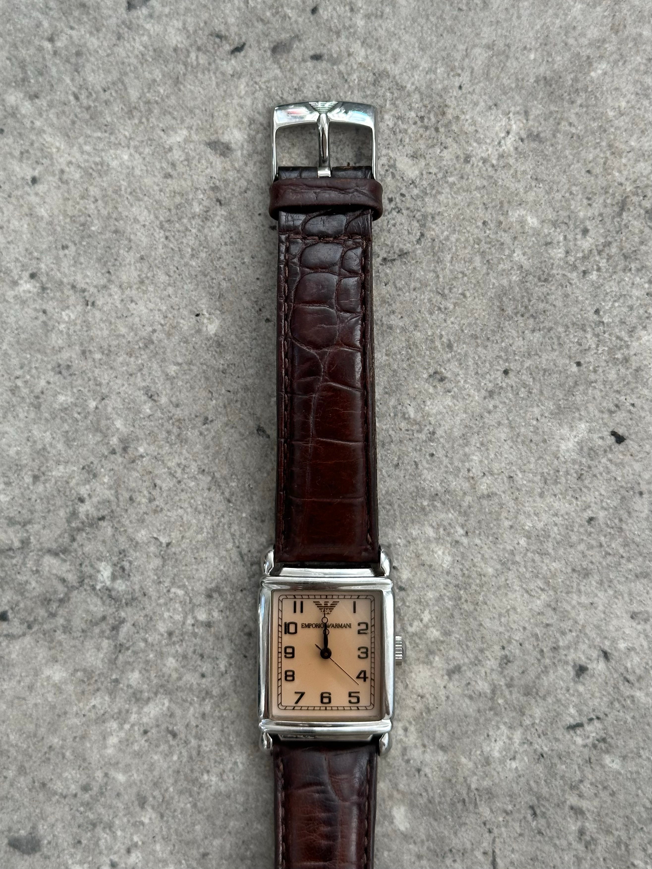 Emporio Armani leather logo watch with black dial, silver case, and leather strap, showcasing classic 2000s design.