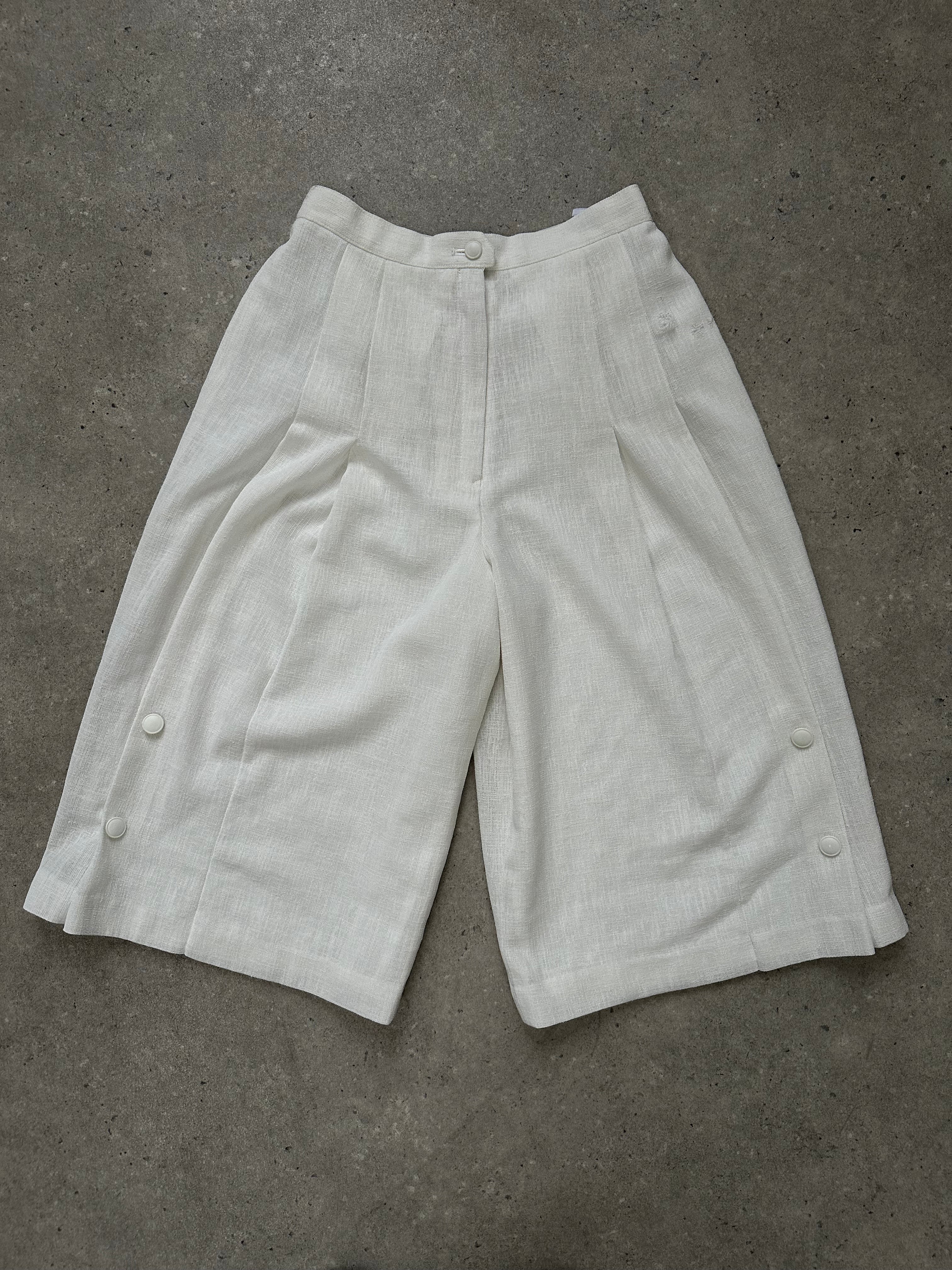 Japanese vintage 1990s high-waisted pleated culottes shorts in beige, featuring wide legs and retro style.