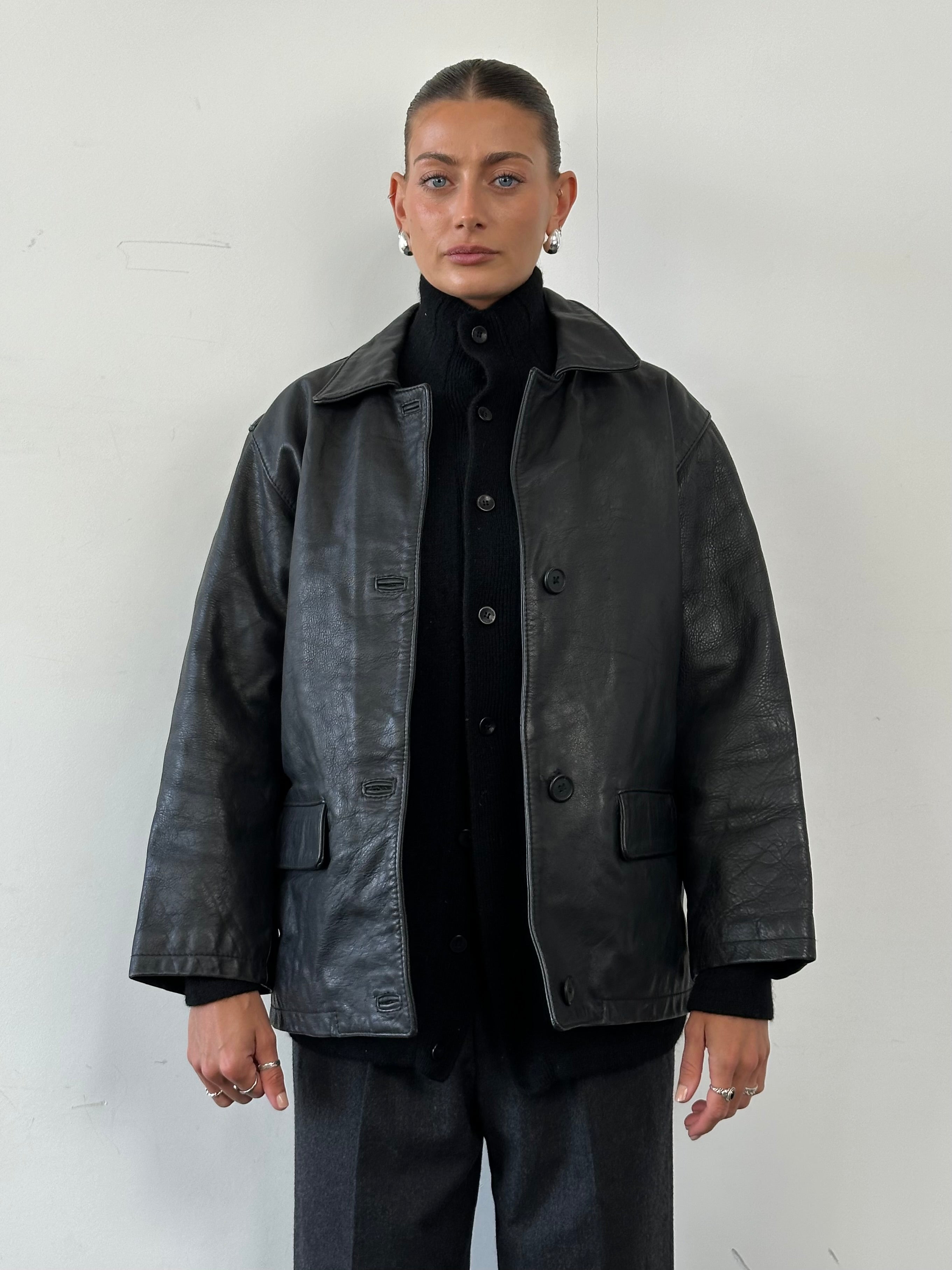 Vintage leather jacket in size M, featuring classic design and durable leather, shown on a hanger.