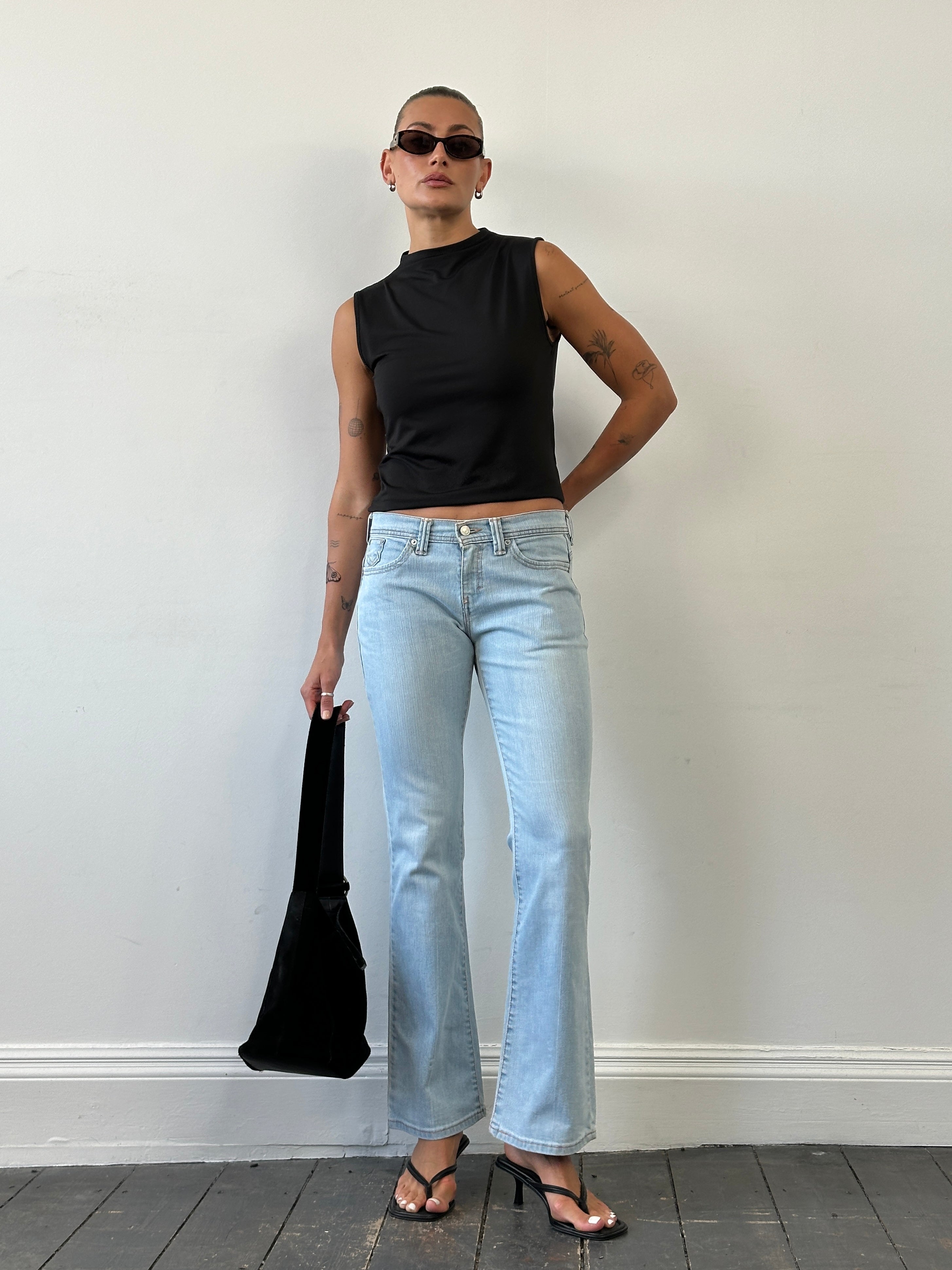 Levi’s low waist flared denim jeans in size W28, showcasing classic blue denim fabric and flared leg design.