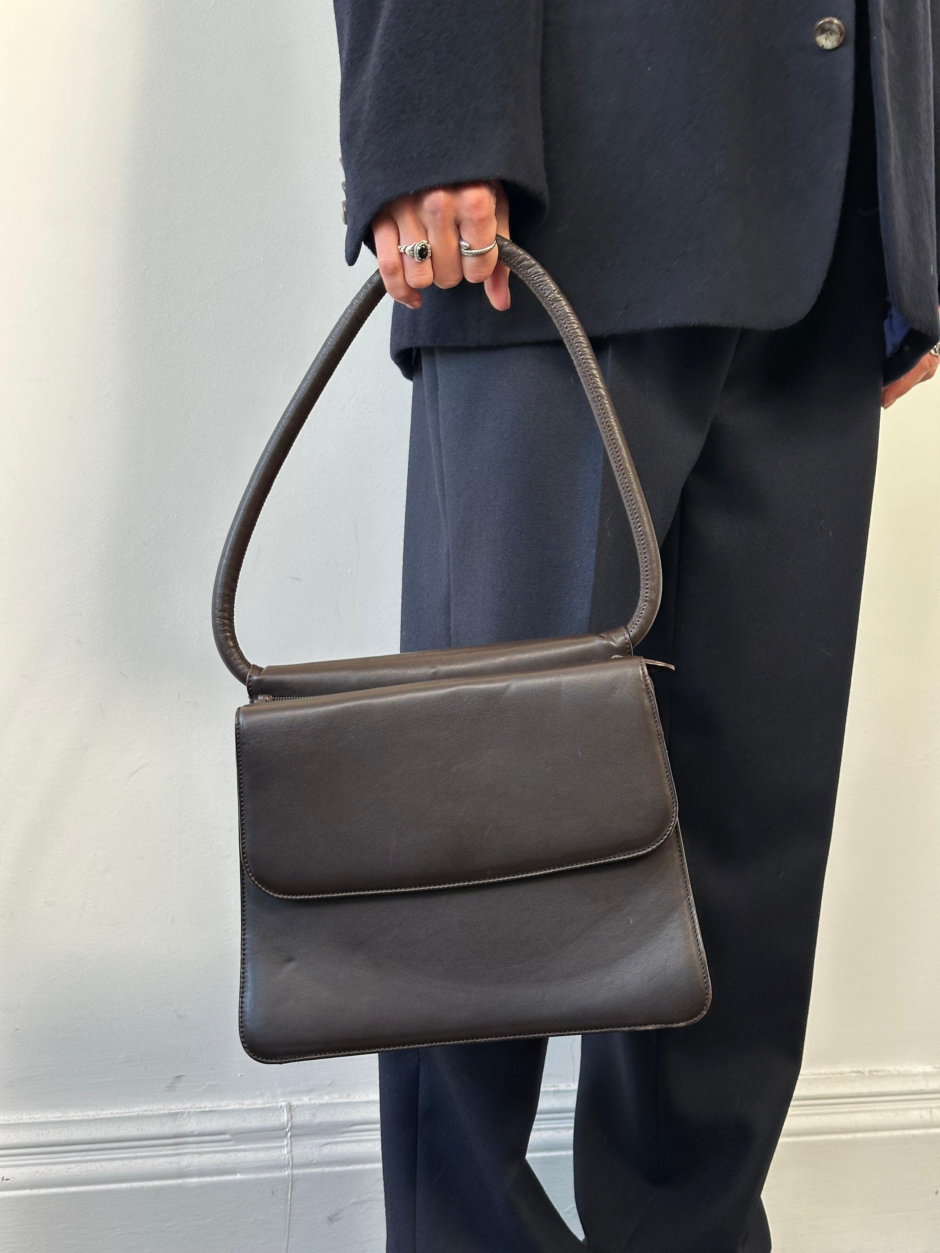 Giorgio Armani Le Collezioni leather shoulder bag in black with sleek design and silver hardware, featuring a top handle and shoulder strap.