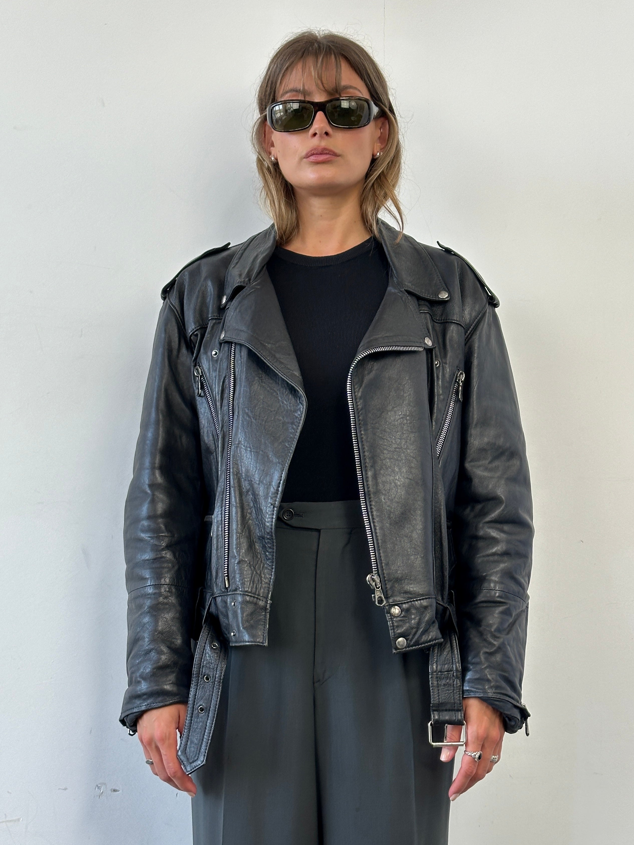 Vintage leather biker jacket in size M/L with classic design, featuring metal zippers and distressed leather detail.