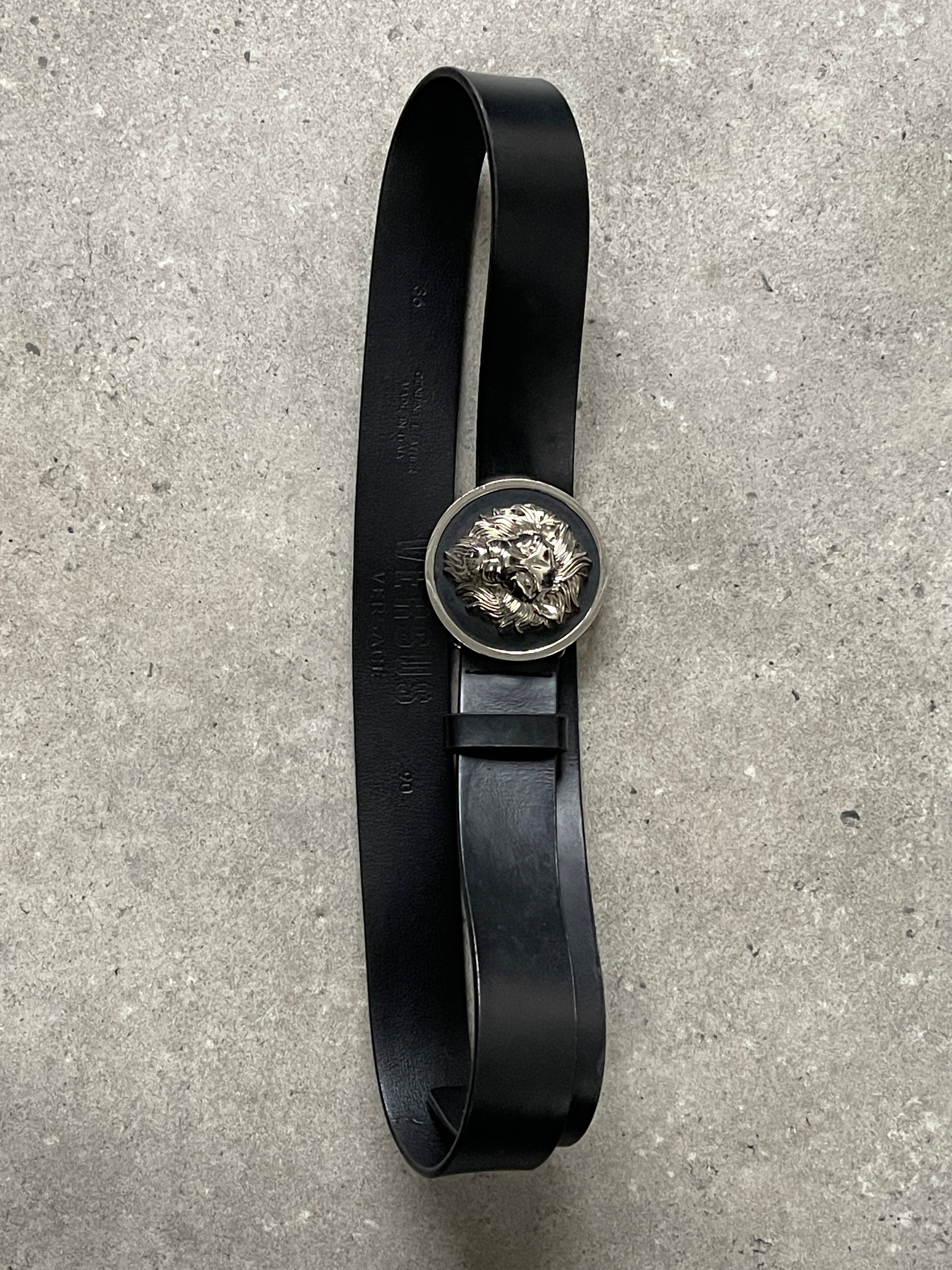 Versace Versus 1990s leather belt with lion head buckle, size W30-38, featuring luxurious black leather and embossed logo detail.