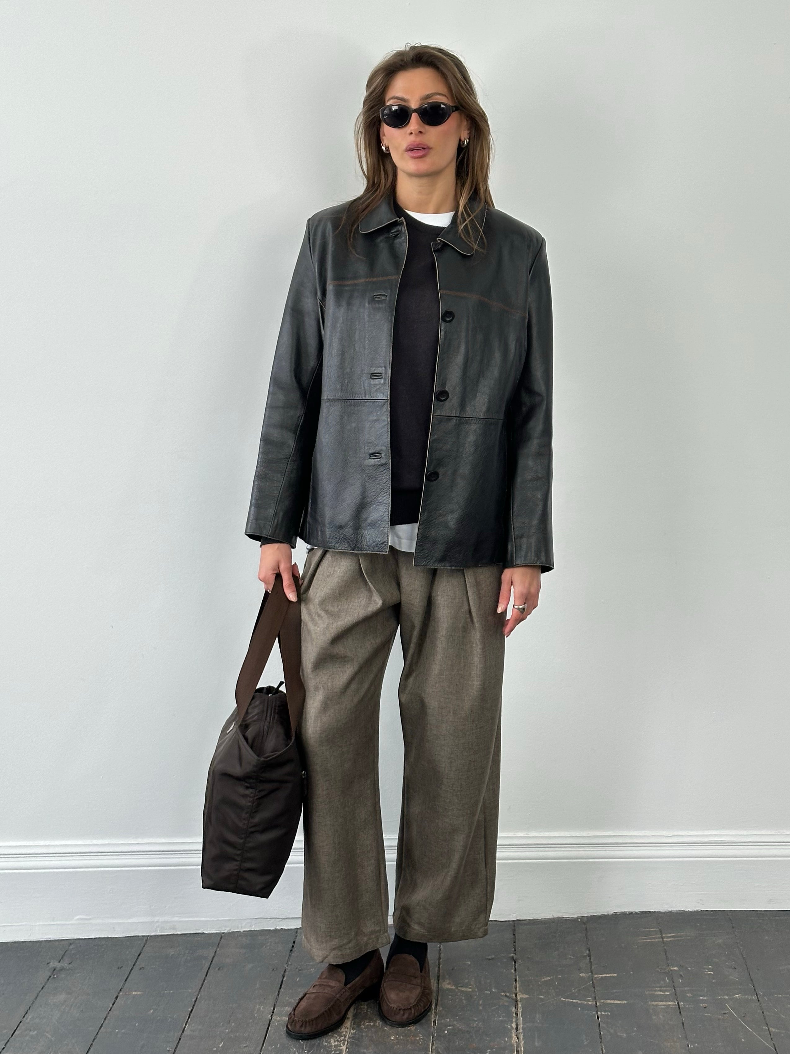Vintage 1990s leather belted jacket, size small, featuring classic leather texture and vintage style with a front belt and collar detail.