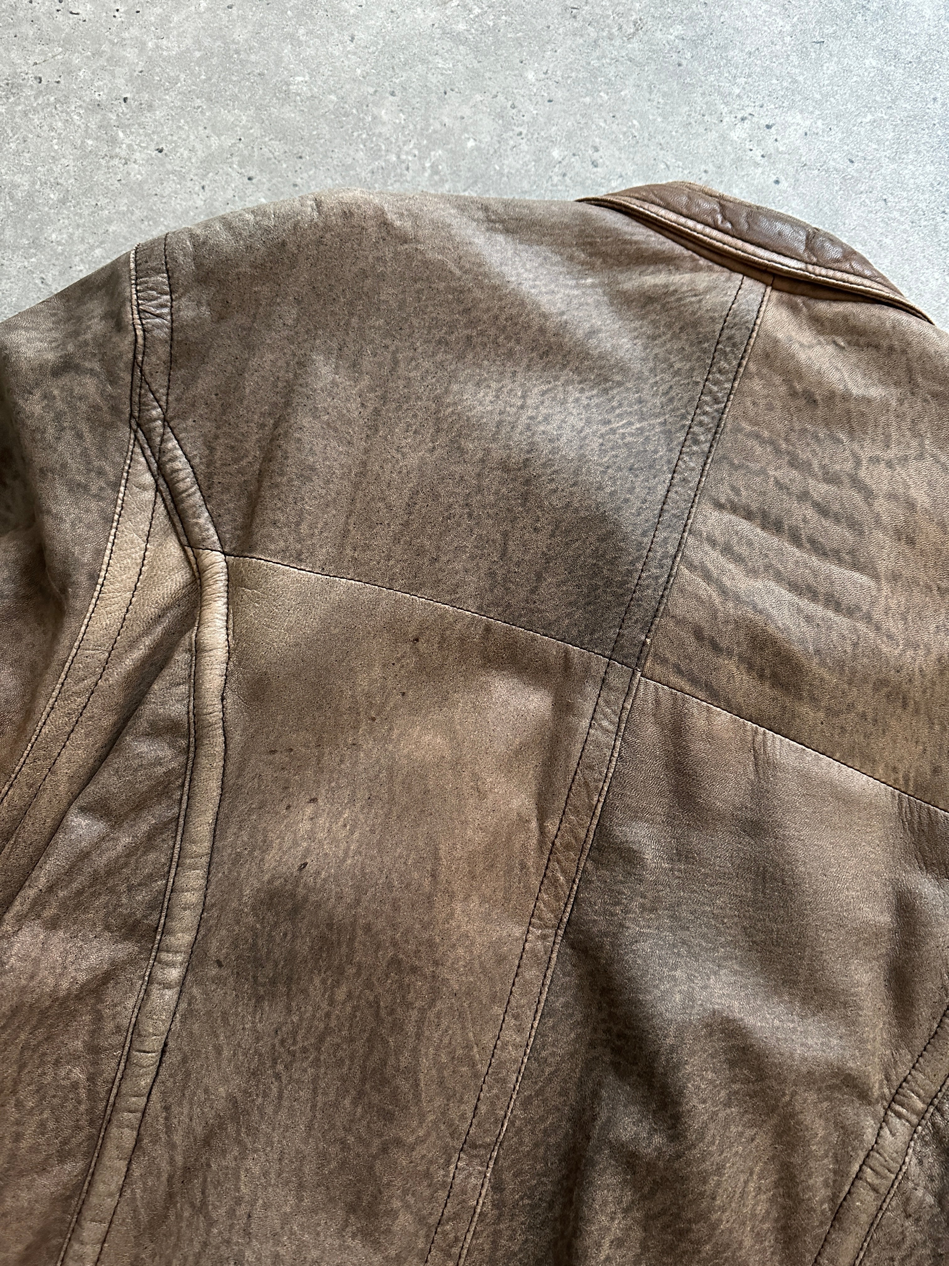 Vintage leather bomber jacket in size L/XL, featuring classic design and durable construction, displayed on a hanger.