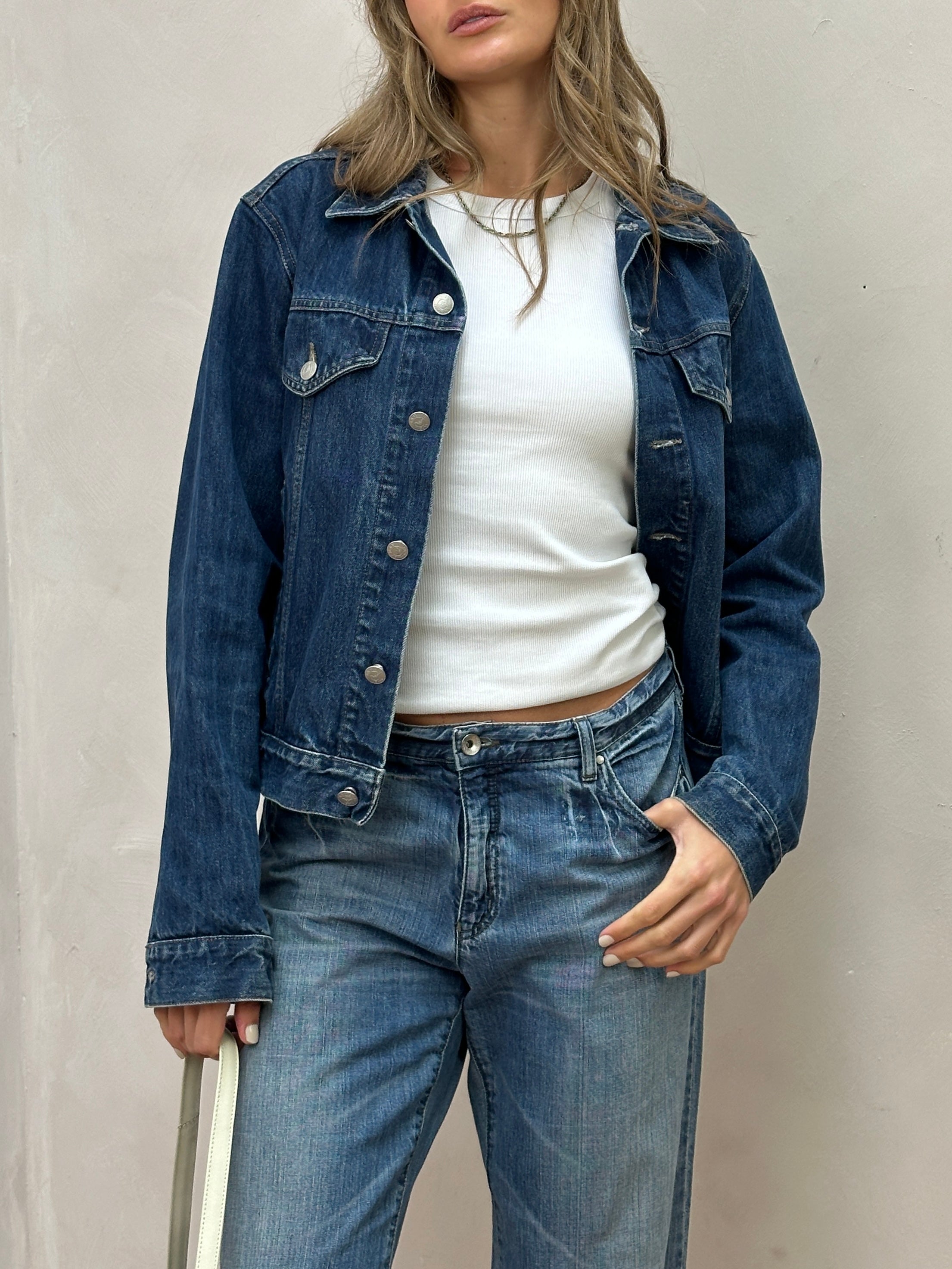 Armani Jeans mid wash denim jacket in size S/M displayed on a hanger, showcasing classic style and stitching details.