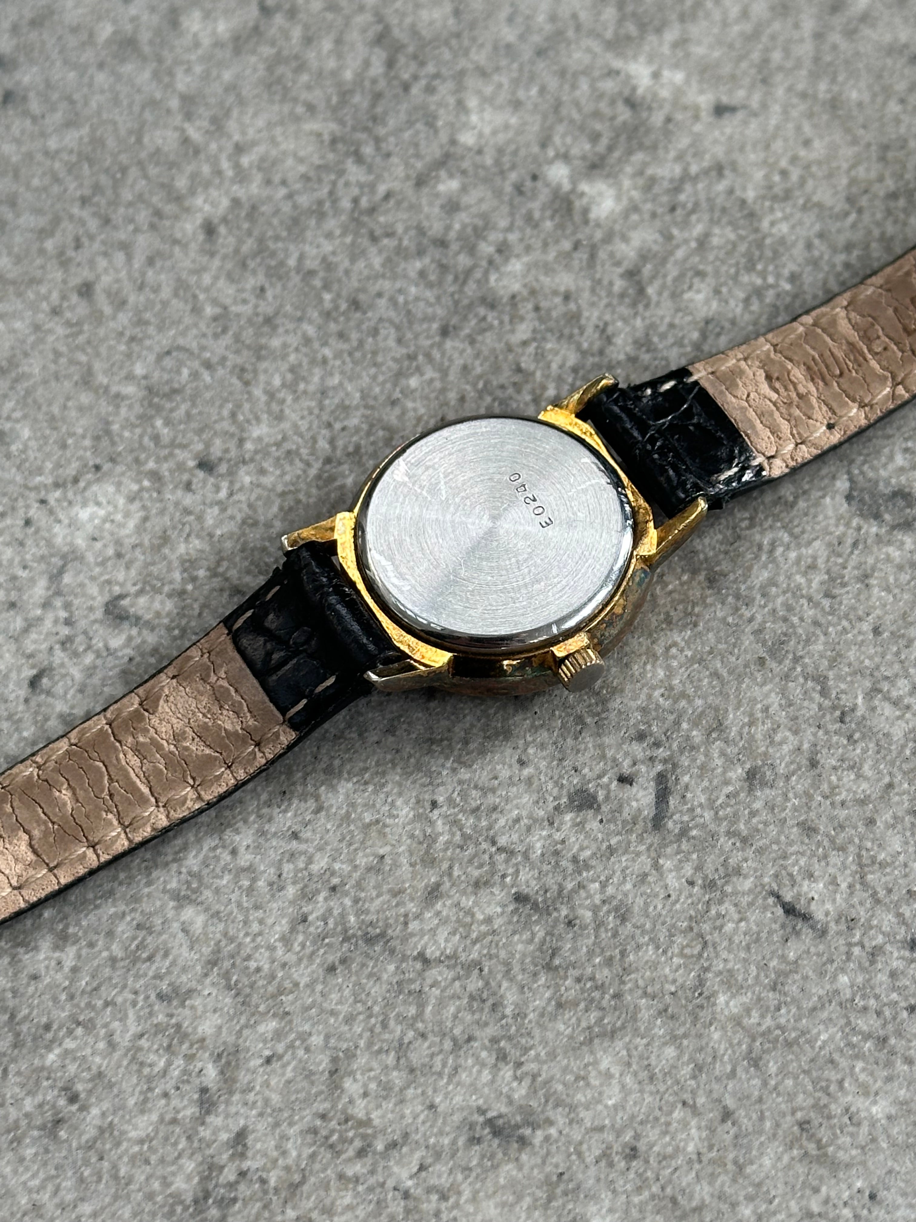 Vintage 1990s round quartz leather watch with a classic design and leather strap, featuring a vintage-style watch face.