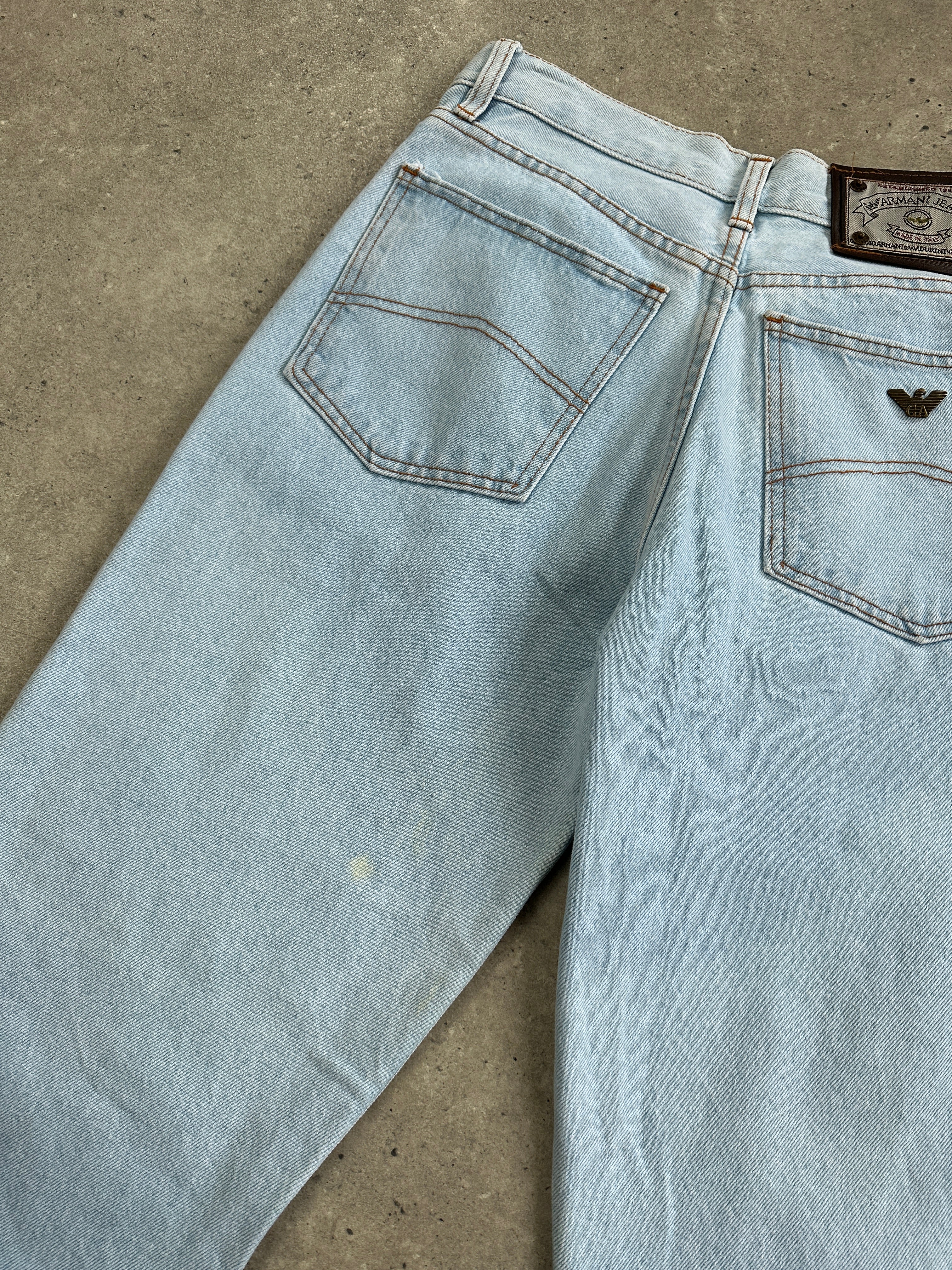 Armani Jeans light wash tapered leg denim jeans with W26 size, showcasing classic five-pocket design and subtle fading.