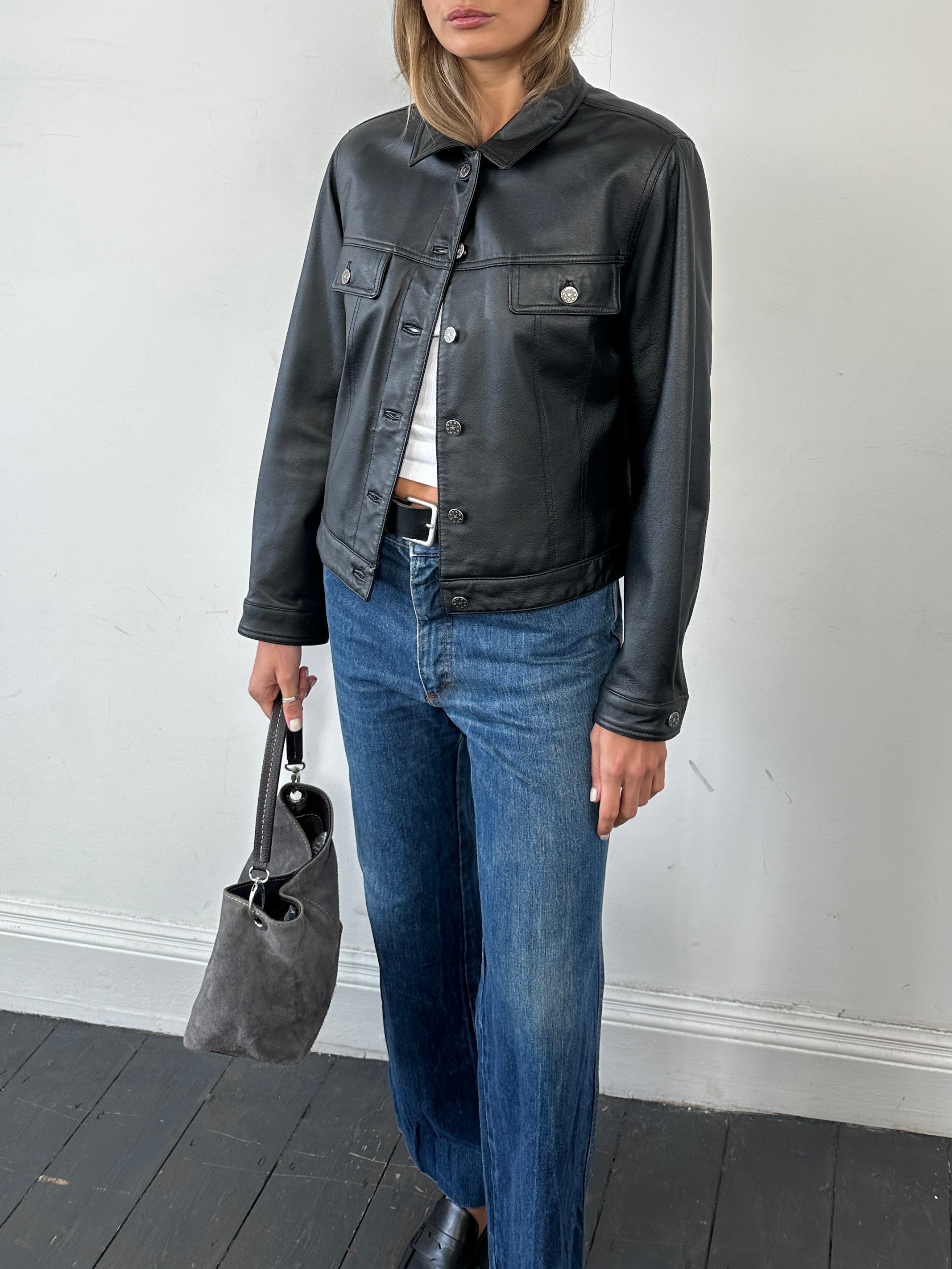 Vintage boxy leather jacket in black, featuring a classic design with a smooth finish, displayed on a neutral background.