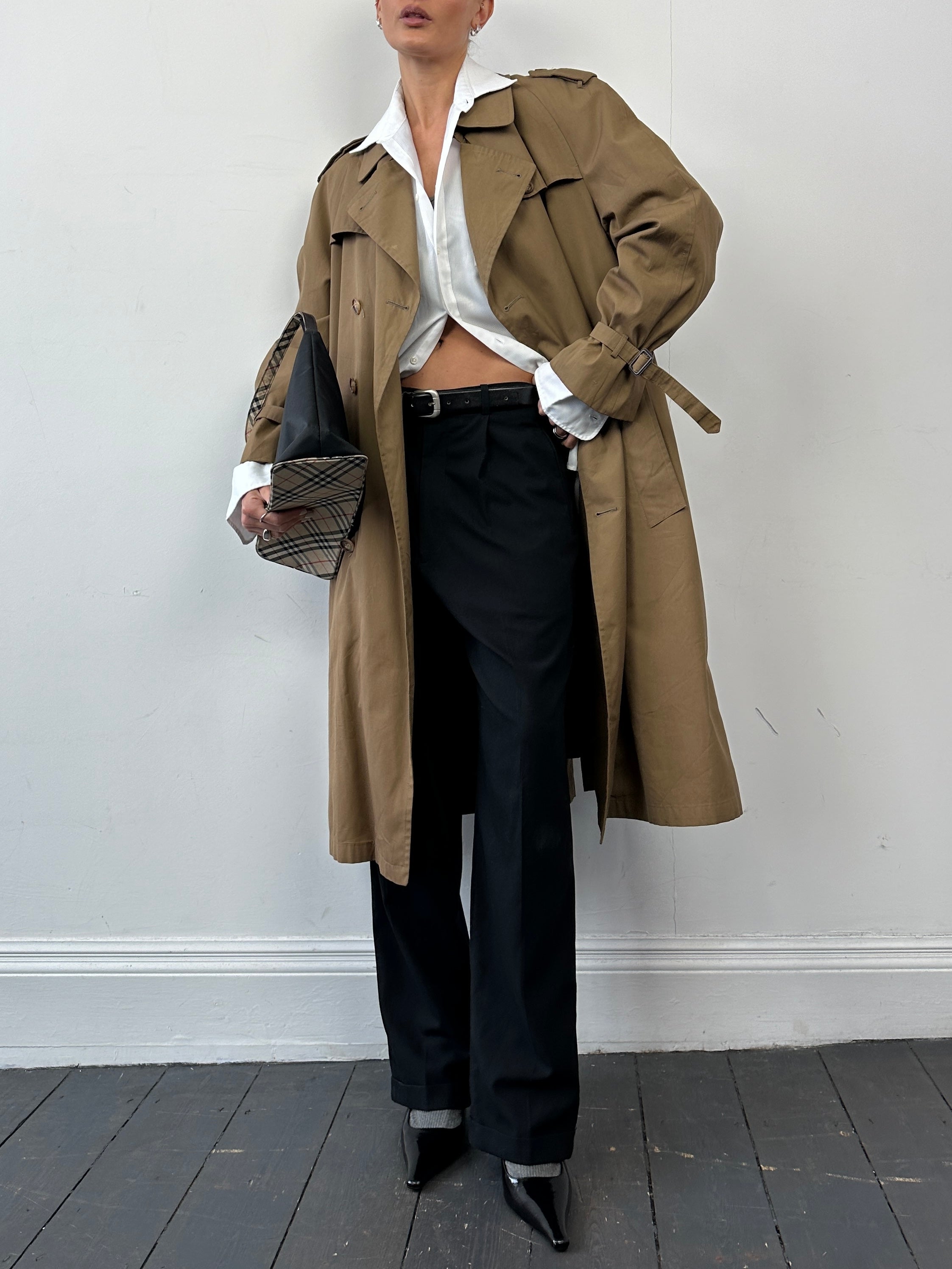 Christian Dior cotton double-breasted trench coat in size L, shown hanging with classic collar and button details.