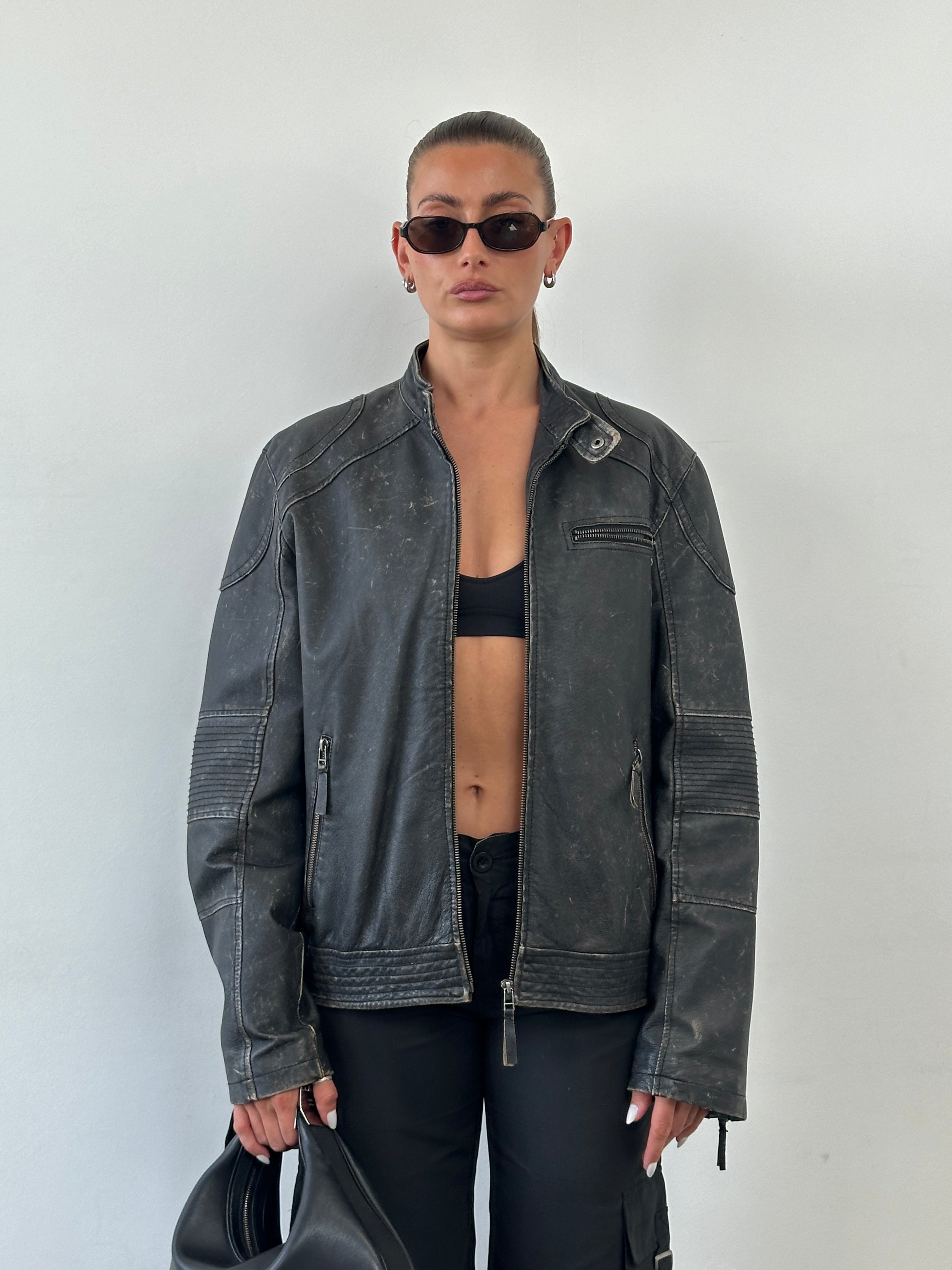 Vintage distressed leather moto jacket in size M/L, featuring rugged details and classic motorcycle style.