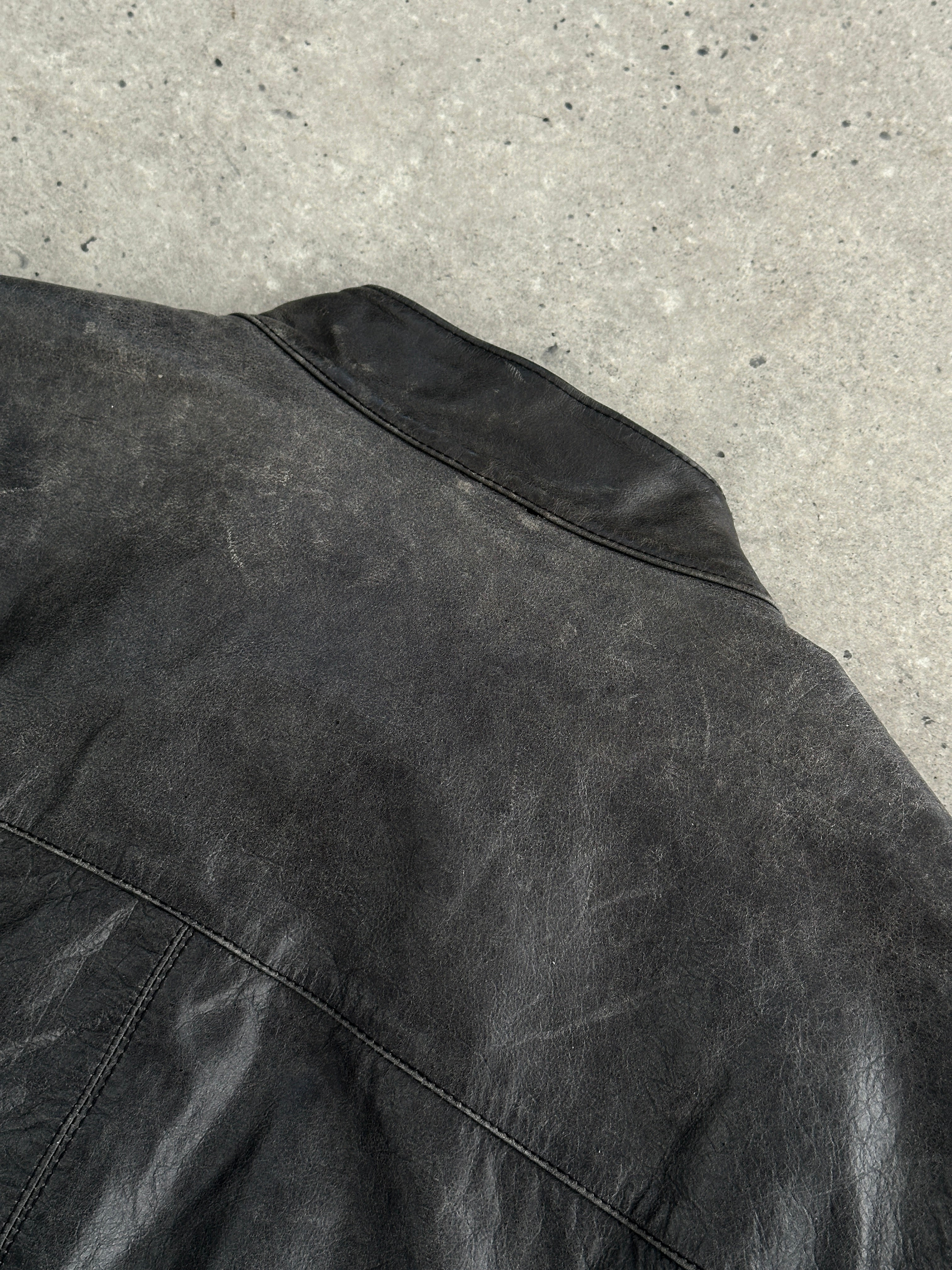 Vintage distressed leather moto jacket in size L/XL, featuring a rugged design with classic hardware and a worn-in leather finish.