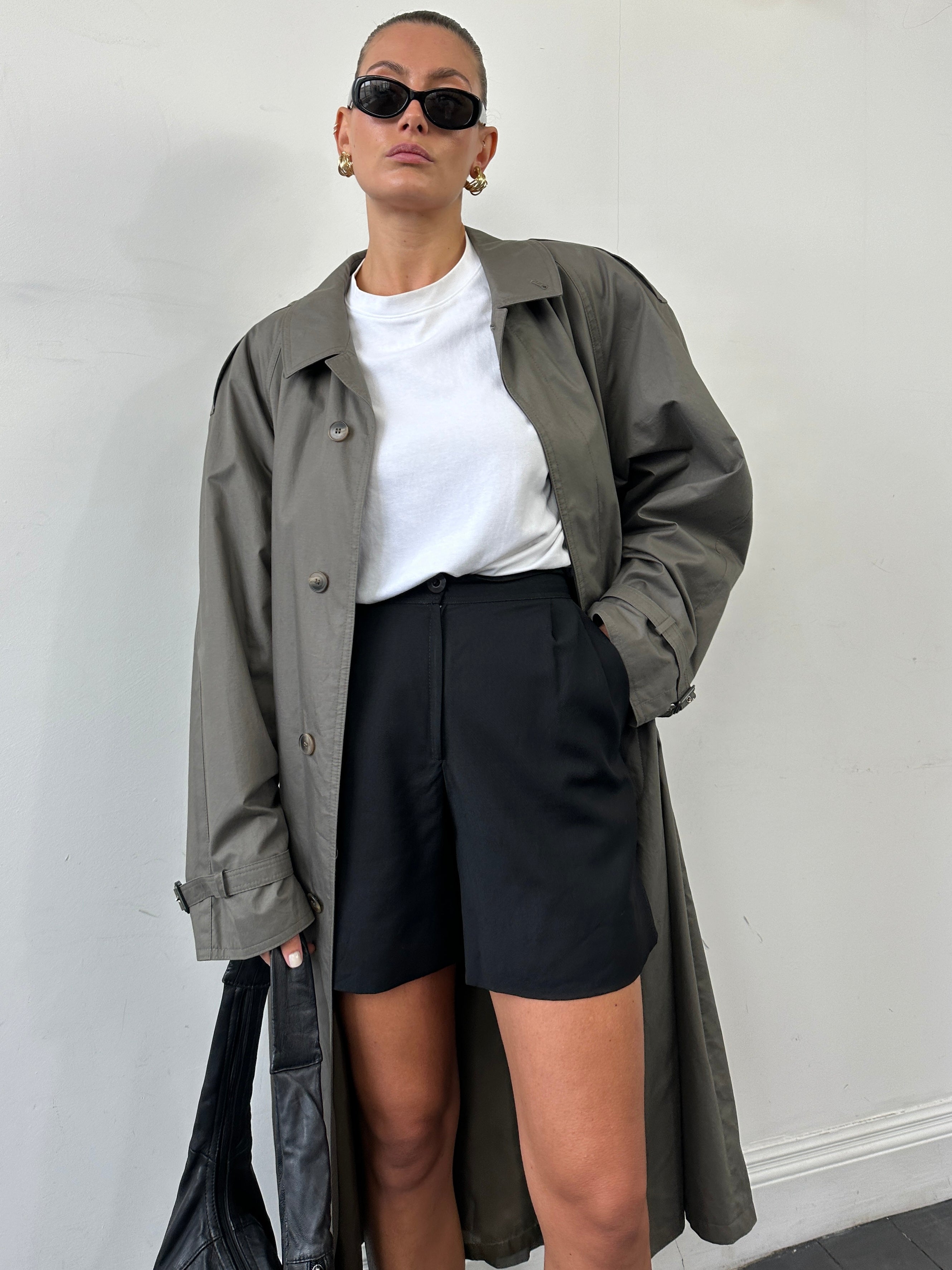 Vintage XL trench coat with concealed placket and belt, classic style, shown hanging on a wooden hanger.