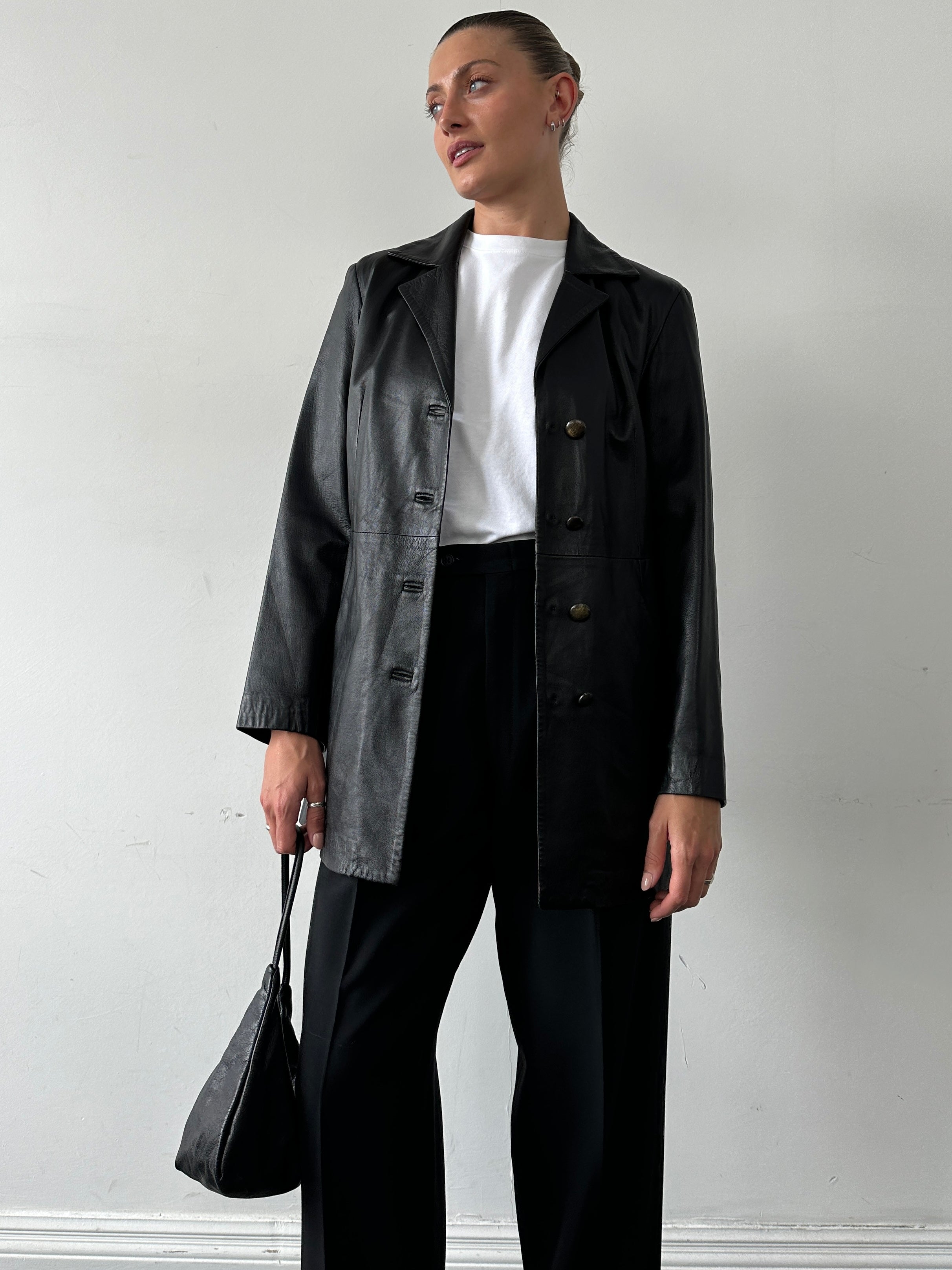 Vintage Italian longline leather jacket in smooth brown leather, stylish and vintage-inspired, displayed on a hanger.