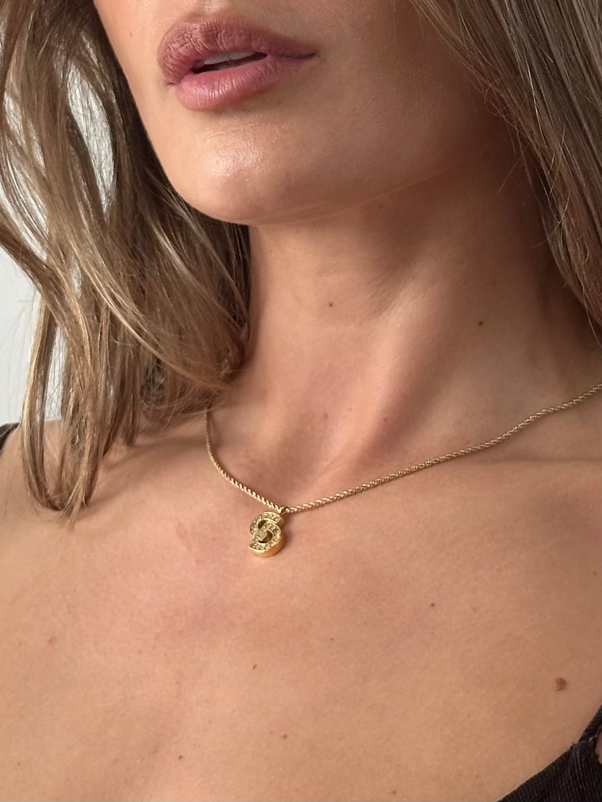 Christian Dior 16-inch gold plated rhinestone logo pendant necklace, featuring a sparkling Dior emblem on a delicate chain.