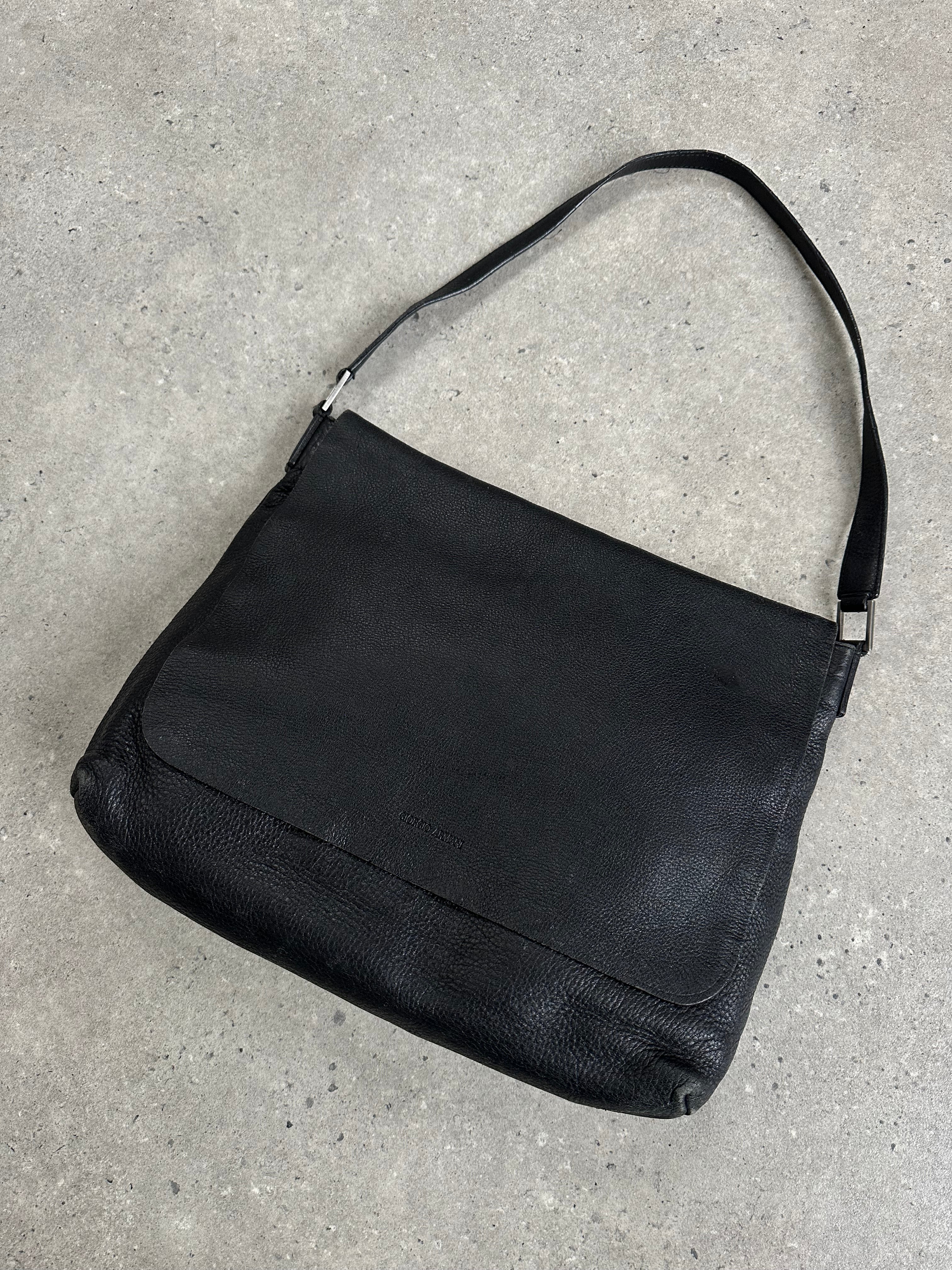 Giorgio Armani 2000s leather crossbody bag in black with adjustable strap and subtle logo detail on front.