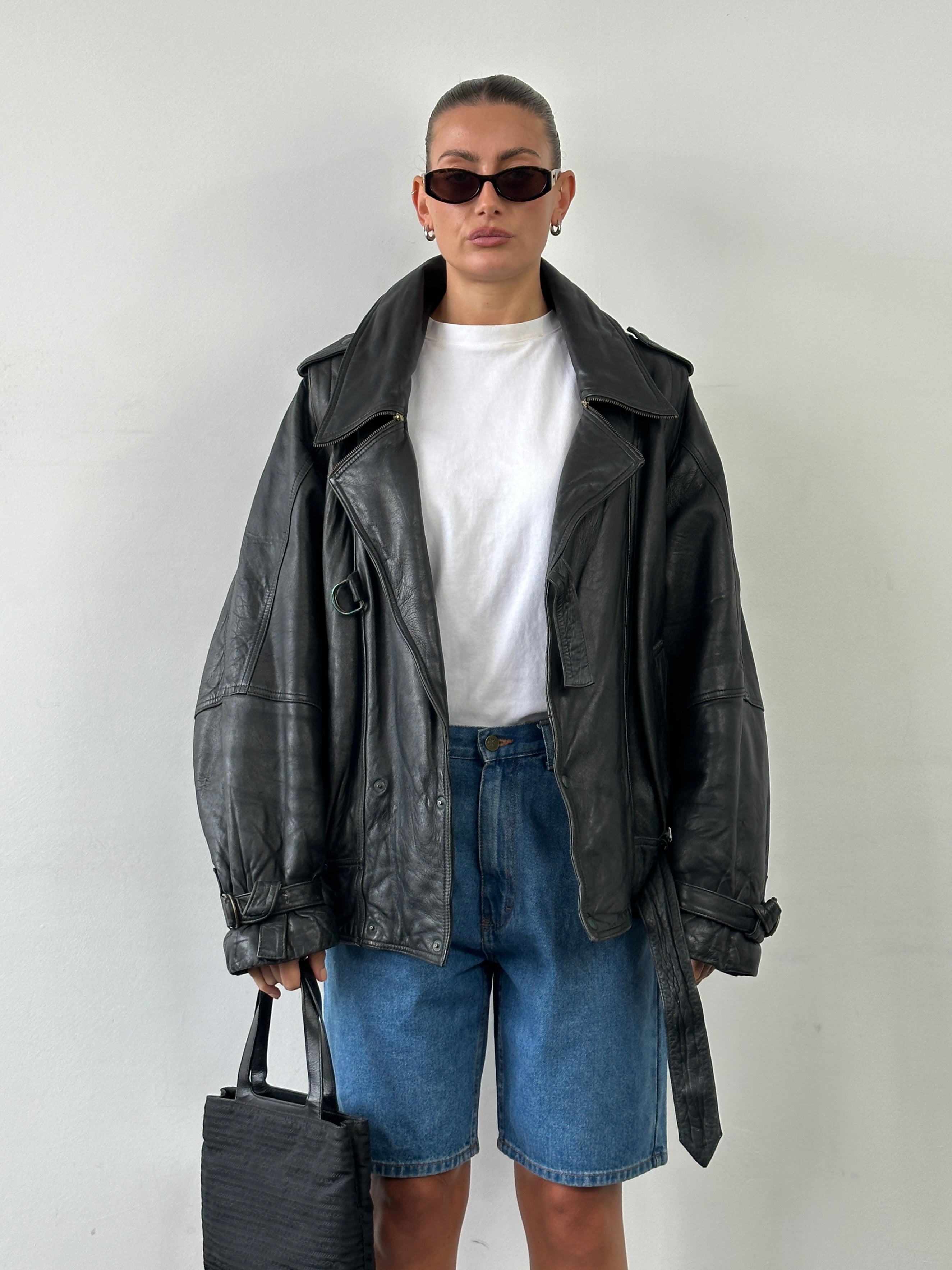 Vintage brand vintage leather jacket with belted buckle in size XL, featuring classic design and detailed stitching.