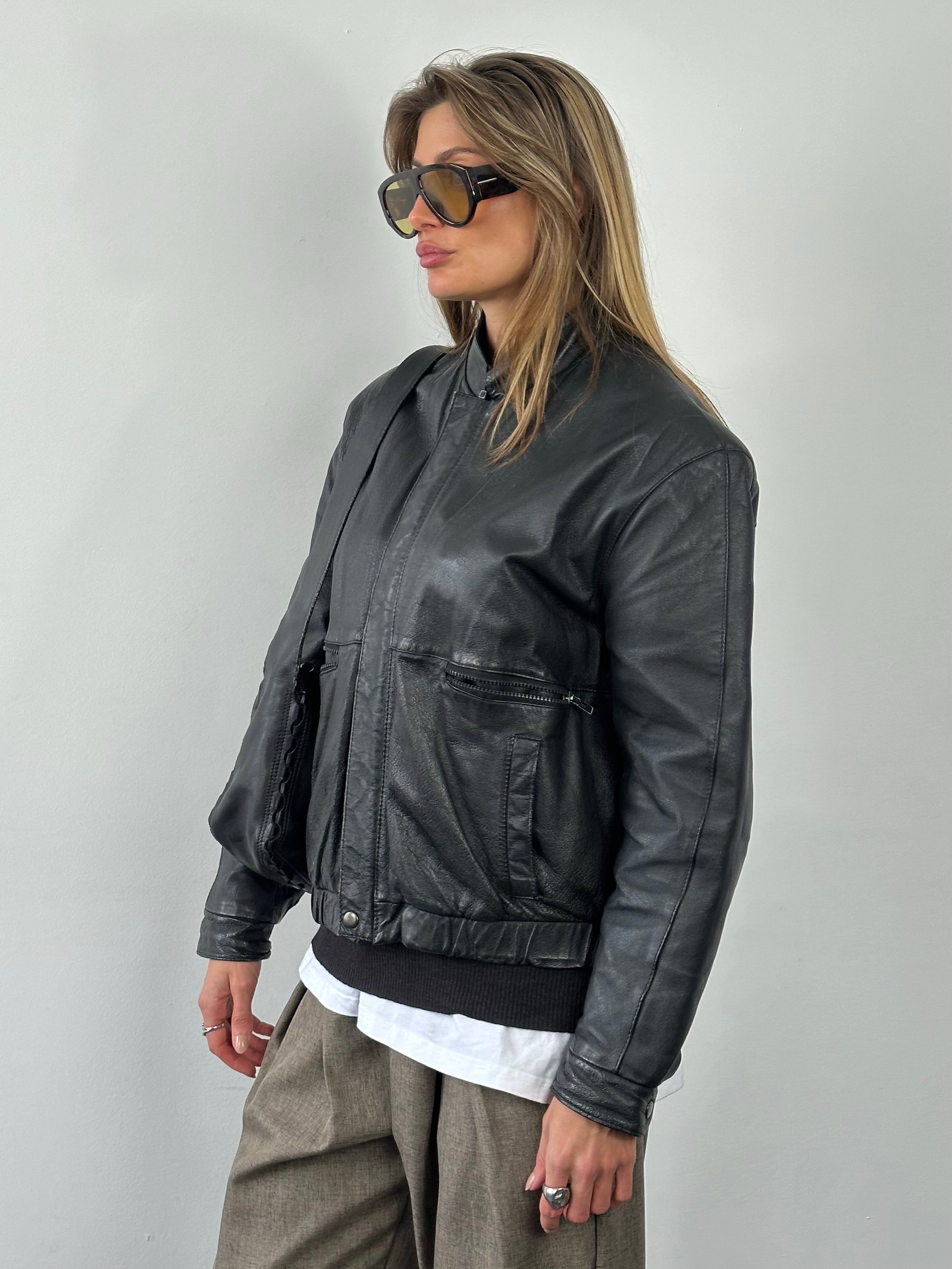 Vintage 1990s minimal leather jacket in size M, showcasing sleek design and classic leather texture.