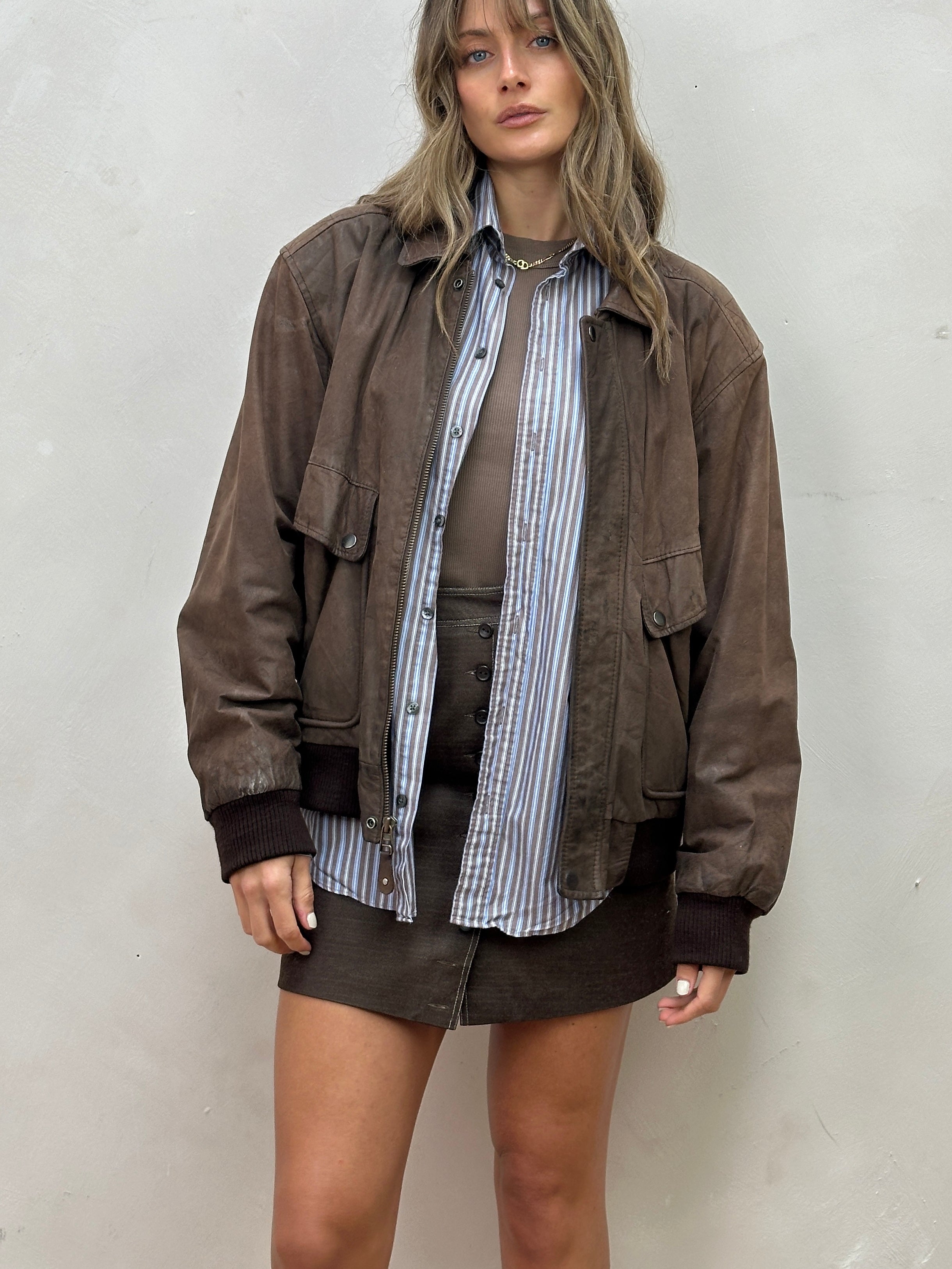 Vintage distressed leather bomber jacket in size large, featuring a classic style with a worn, rugged finish.