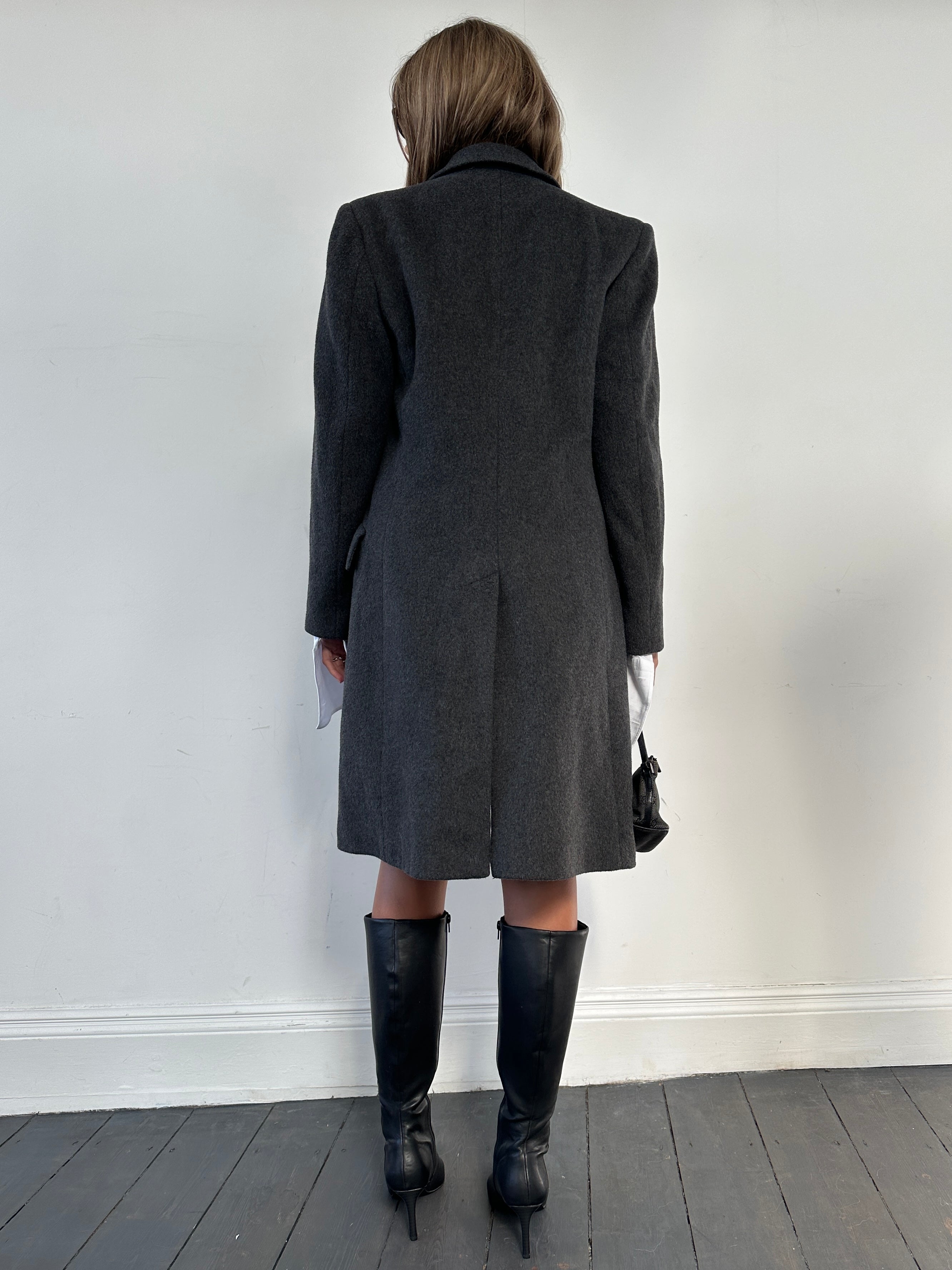Vintage wool cashmere coat in size small/medium displayed on a hanger, showcasing its classic design and cozy texture.