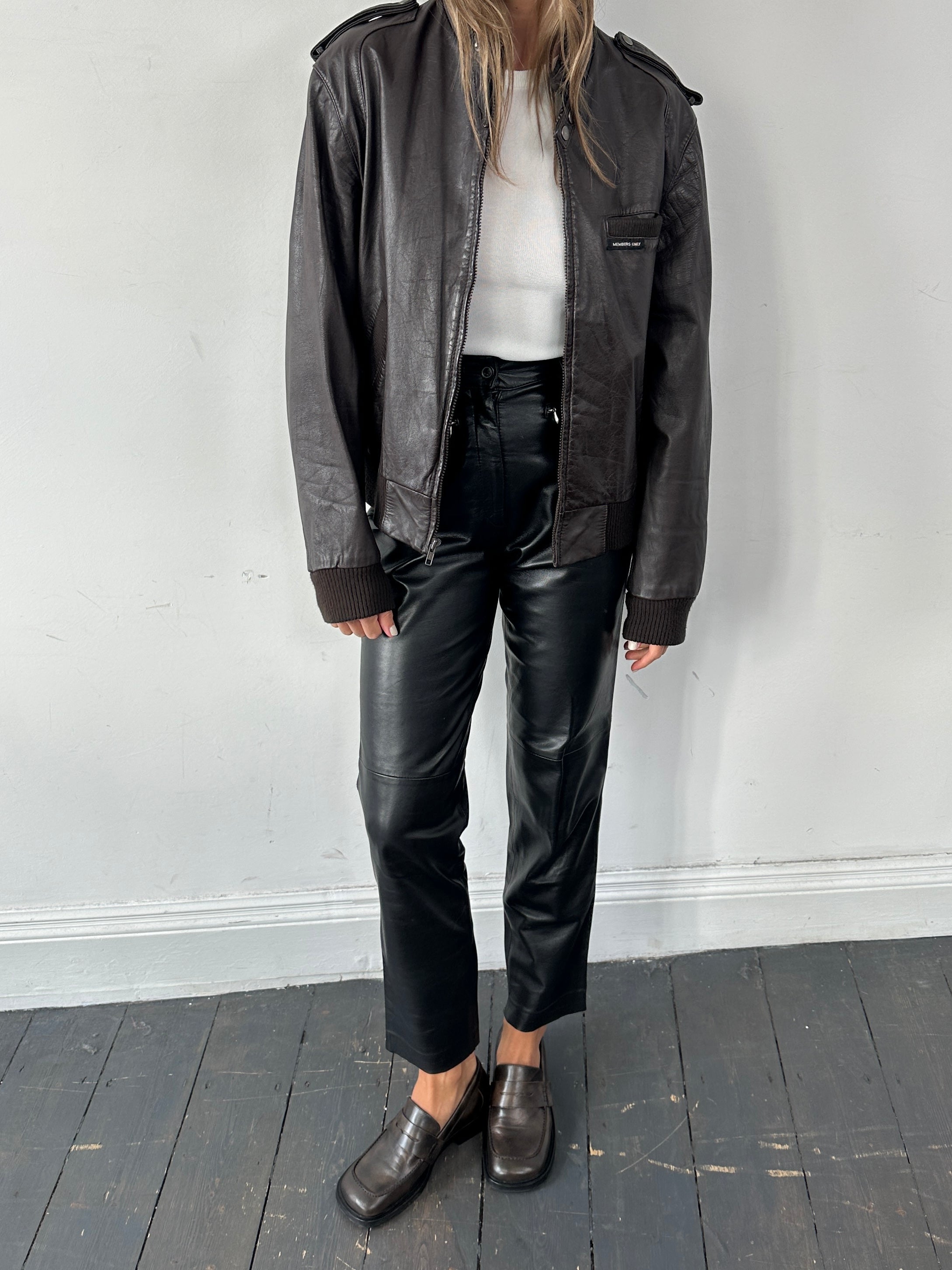 Vintage high waisted smooth leather trousers in black, featuring a classic fit and sleek design, size W26.