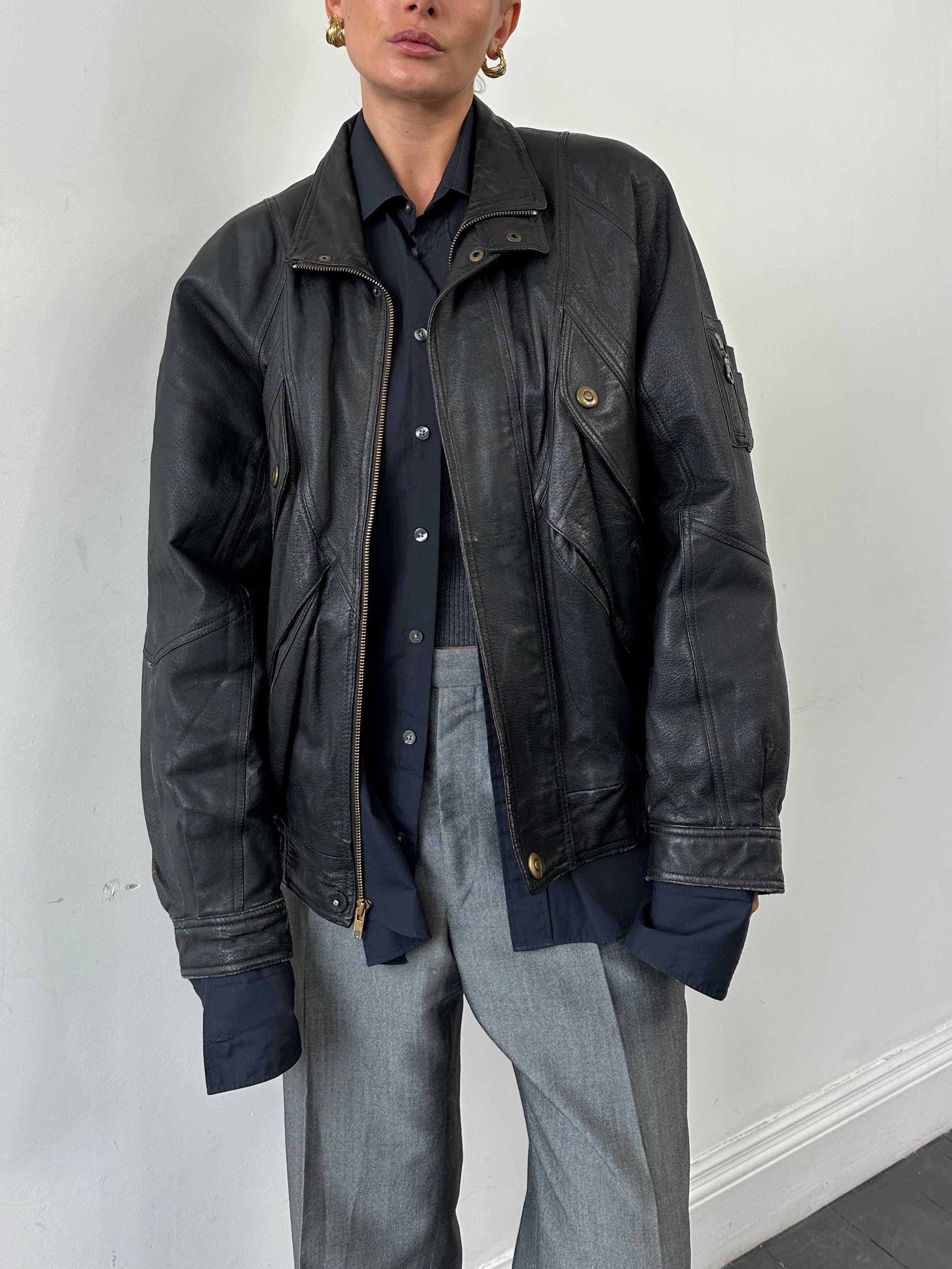 Vintage leather bomber jacket in size L/XL, featuring classic design, ribbed cuffs, and a rugged, timeless look.