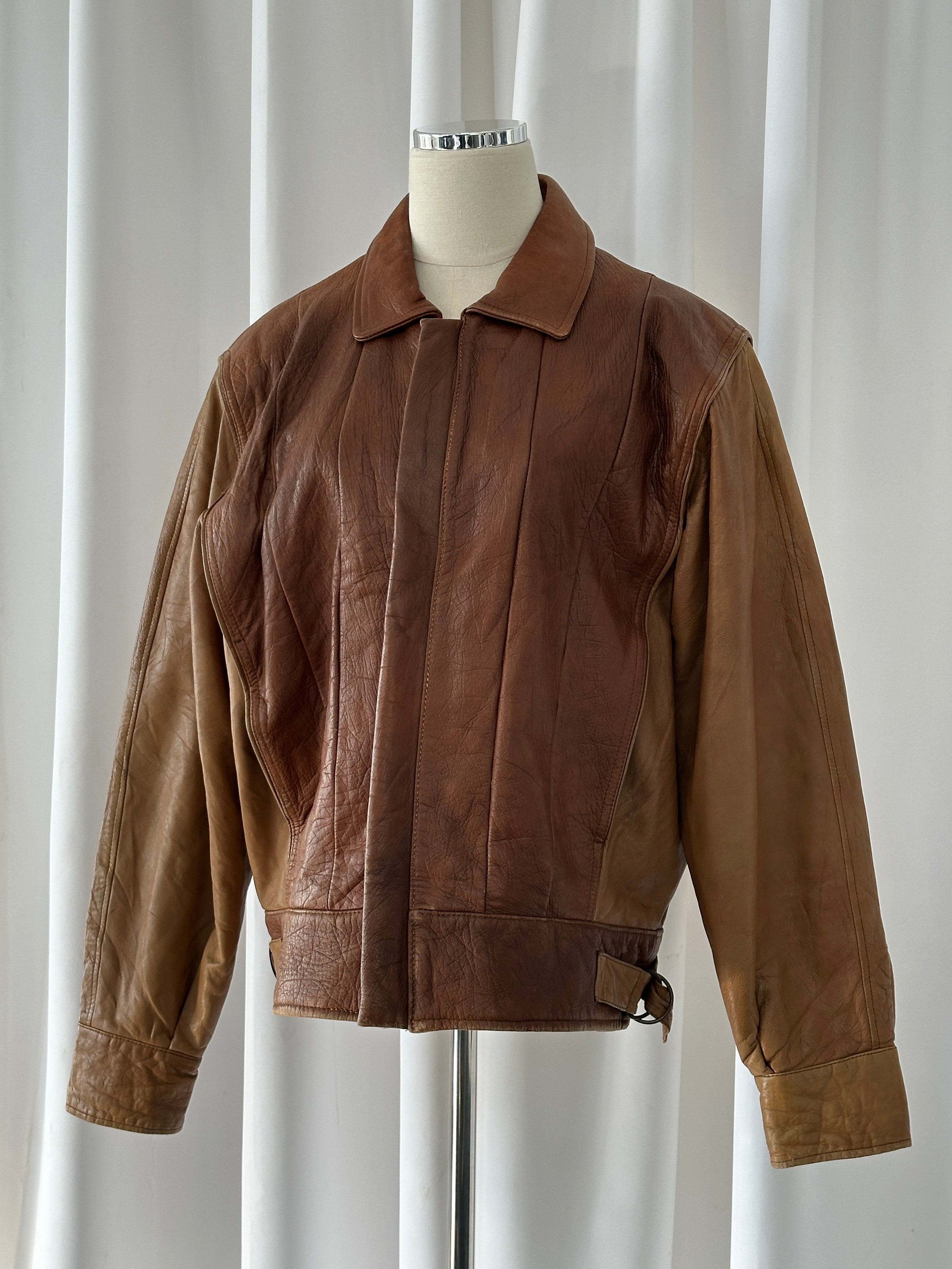 Vintage Italian 1980s leather bomber jacket in size M/L with classic distressed leather and retro style.