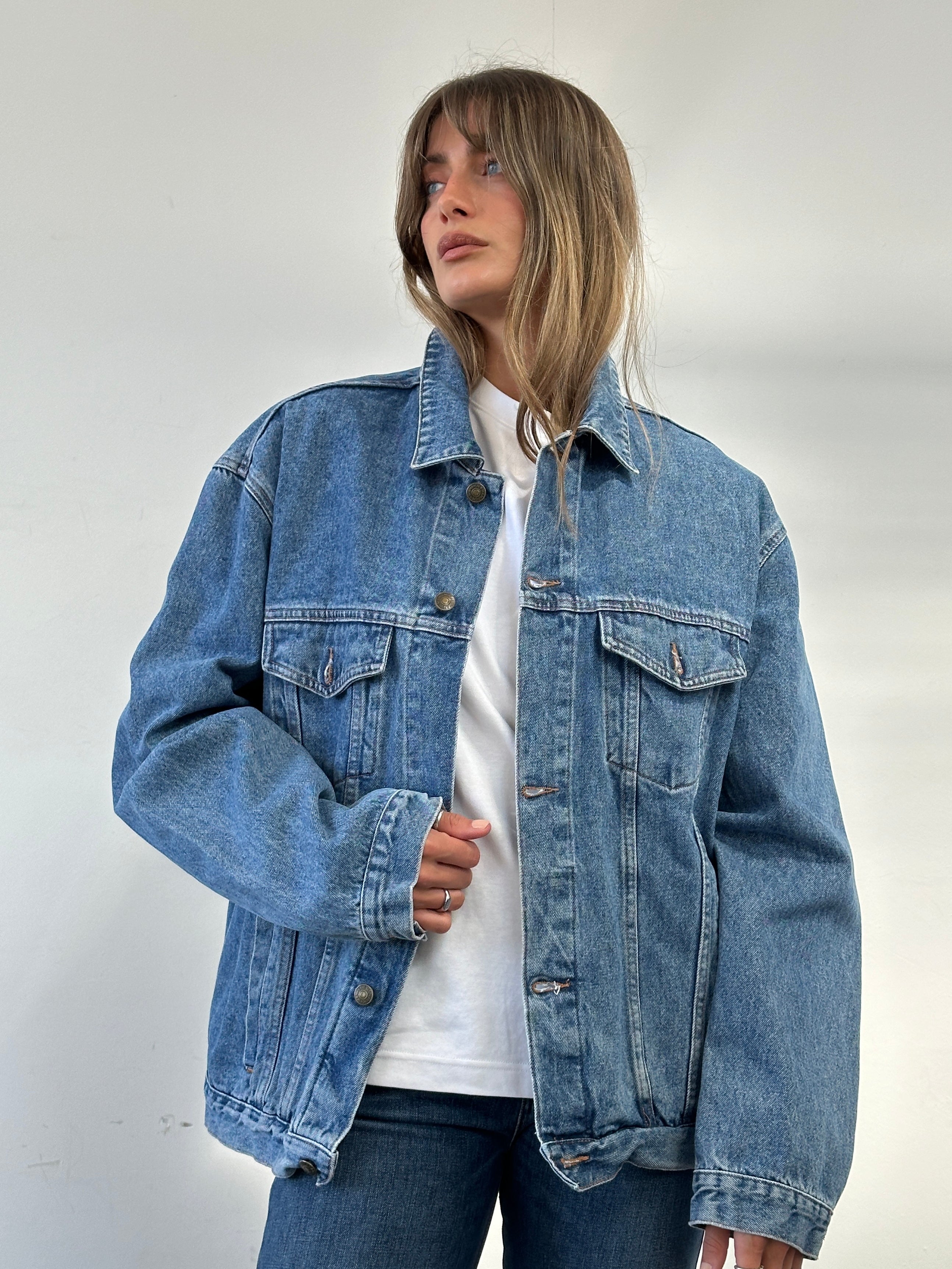 Vintage oversized pure cotton denim jacket in XL with classic style, shown on a hanger with visible stitching and button details.