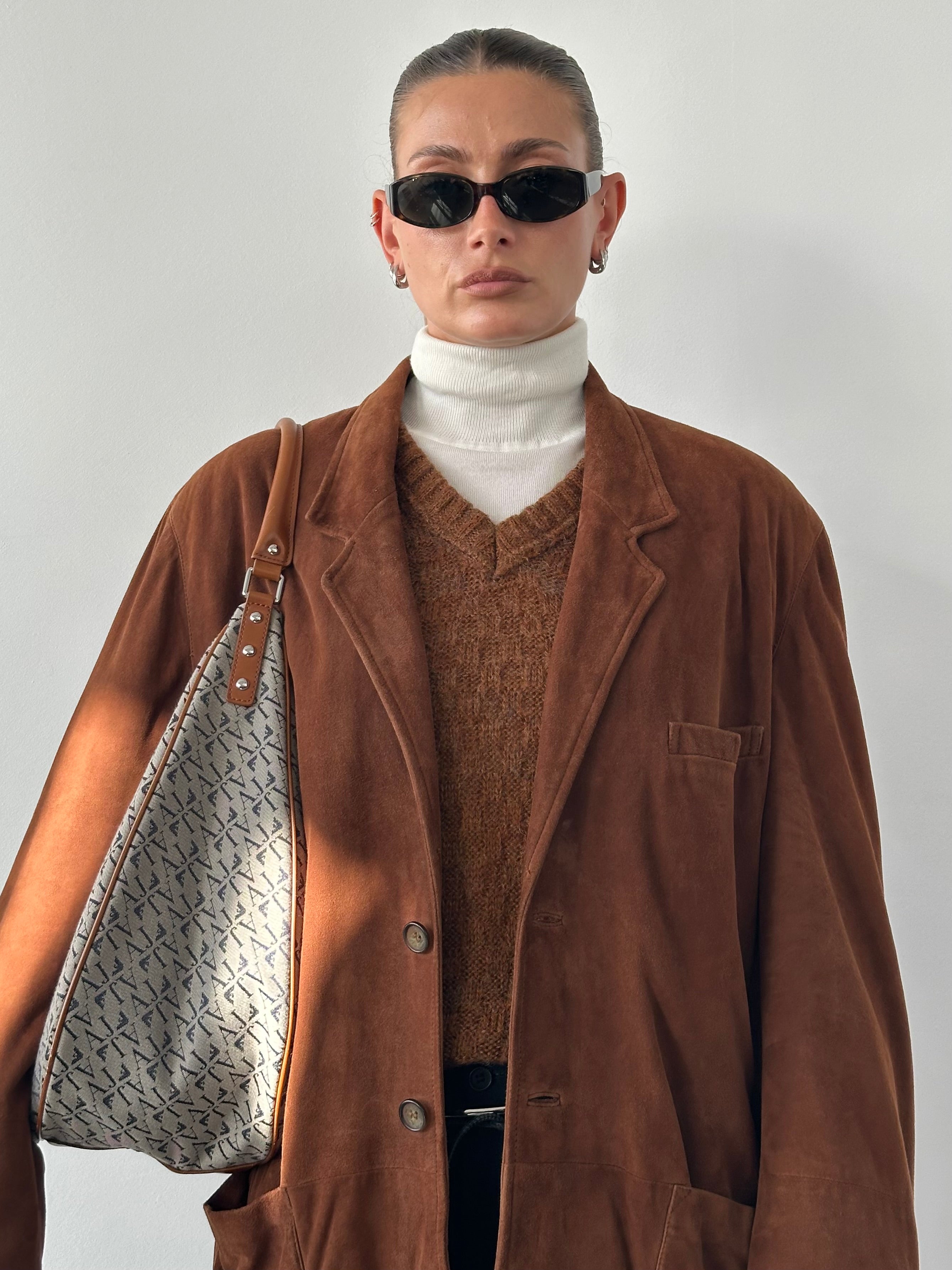 Vintage relaxed fit suede leather blazer in XL size, shown on a hanger with visible soft suede texture and classic tailored design.