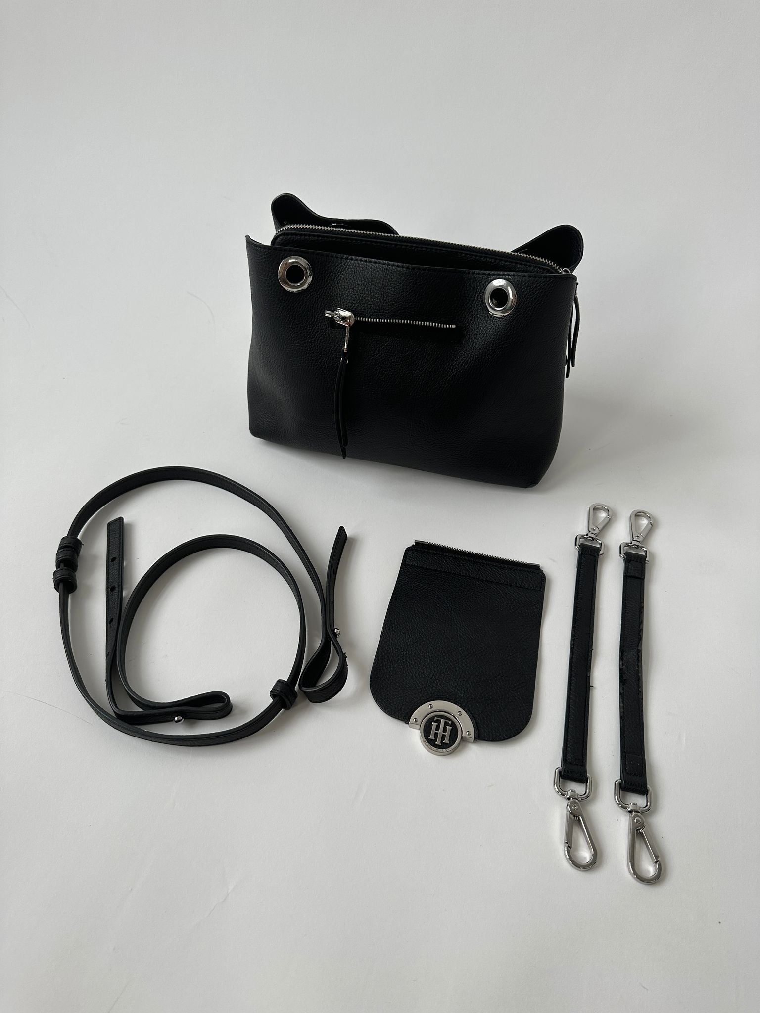 Tommy Hilfiger crossbody bag with adjustable strap, navy blue color, and signature logo detail on the front.