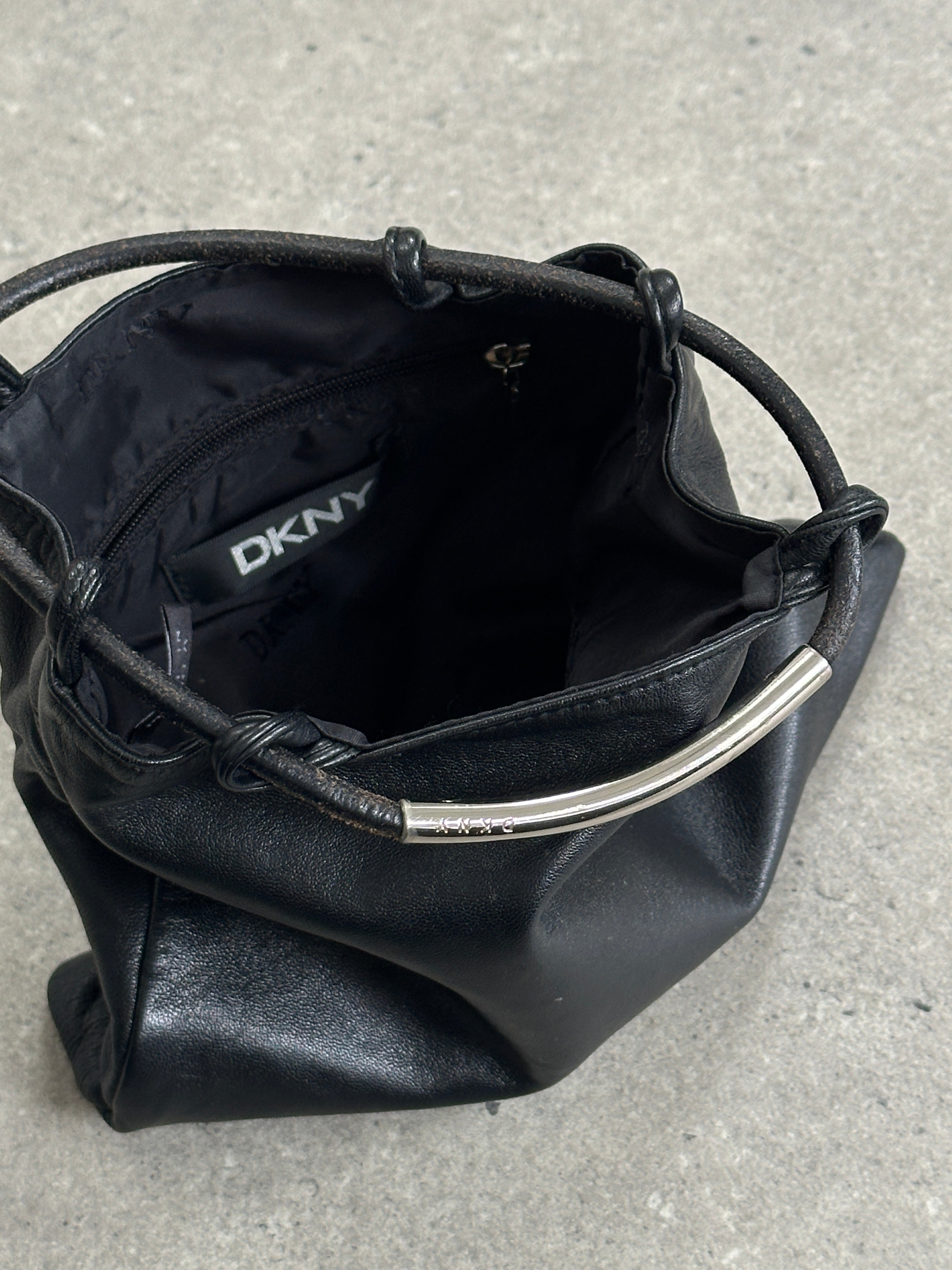DKNY soft leather clutch bag with sleek design and subtle stitching, ideal for elegant evening or day events.