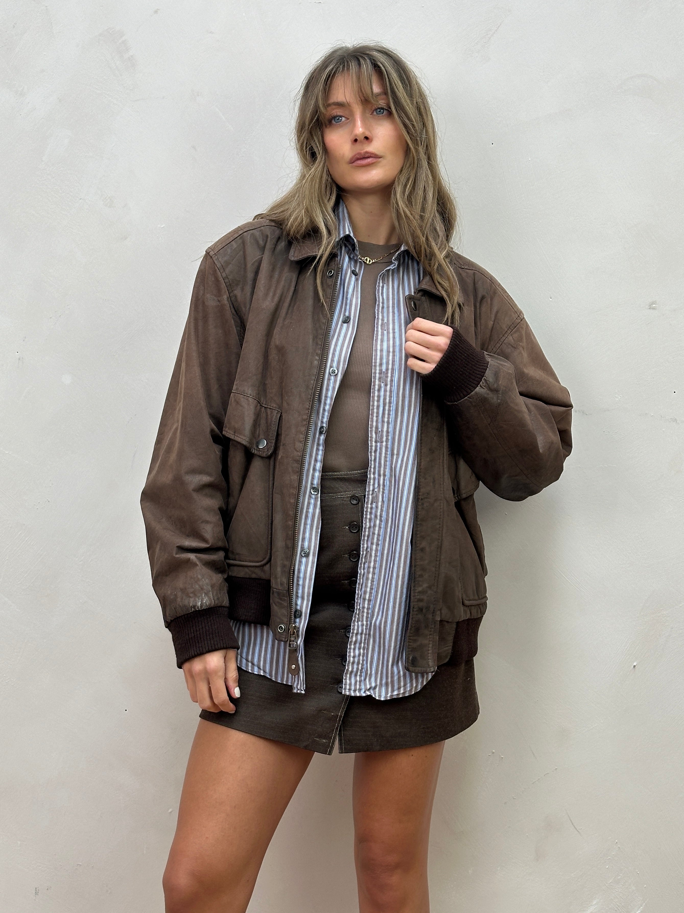 Vintage distressed leather bomber jacket in size L, featuring a rugged style with weathered leather and classic design details.