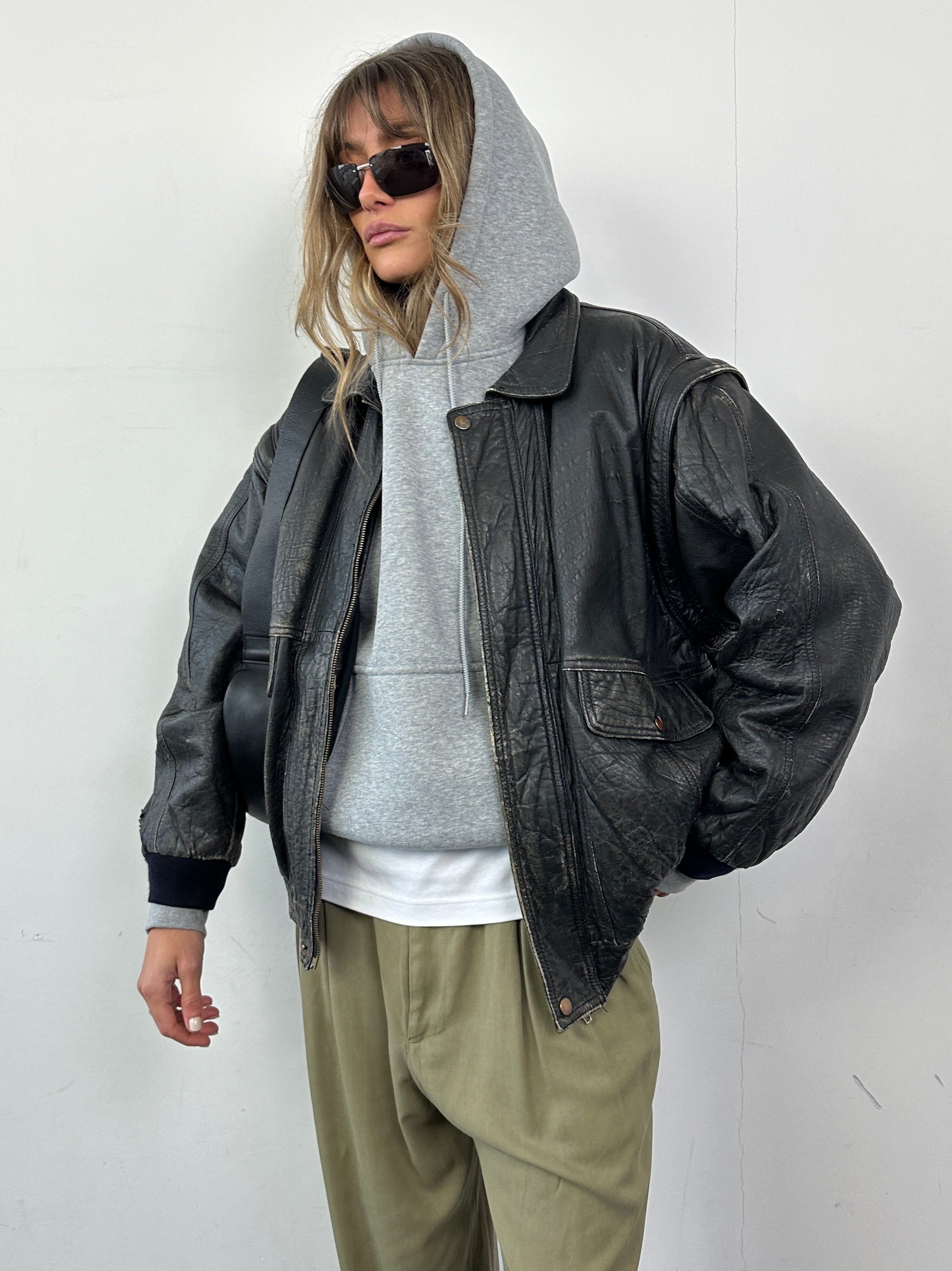 Vintage distressed leather bomber gilet jacket in M/L size, featuring rugged leather texture and classic design.