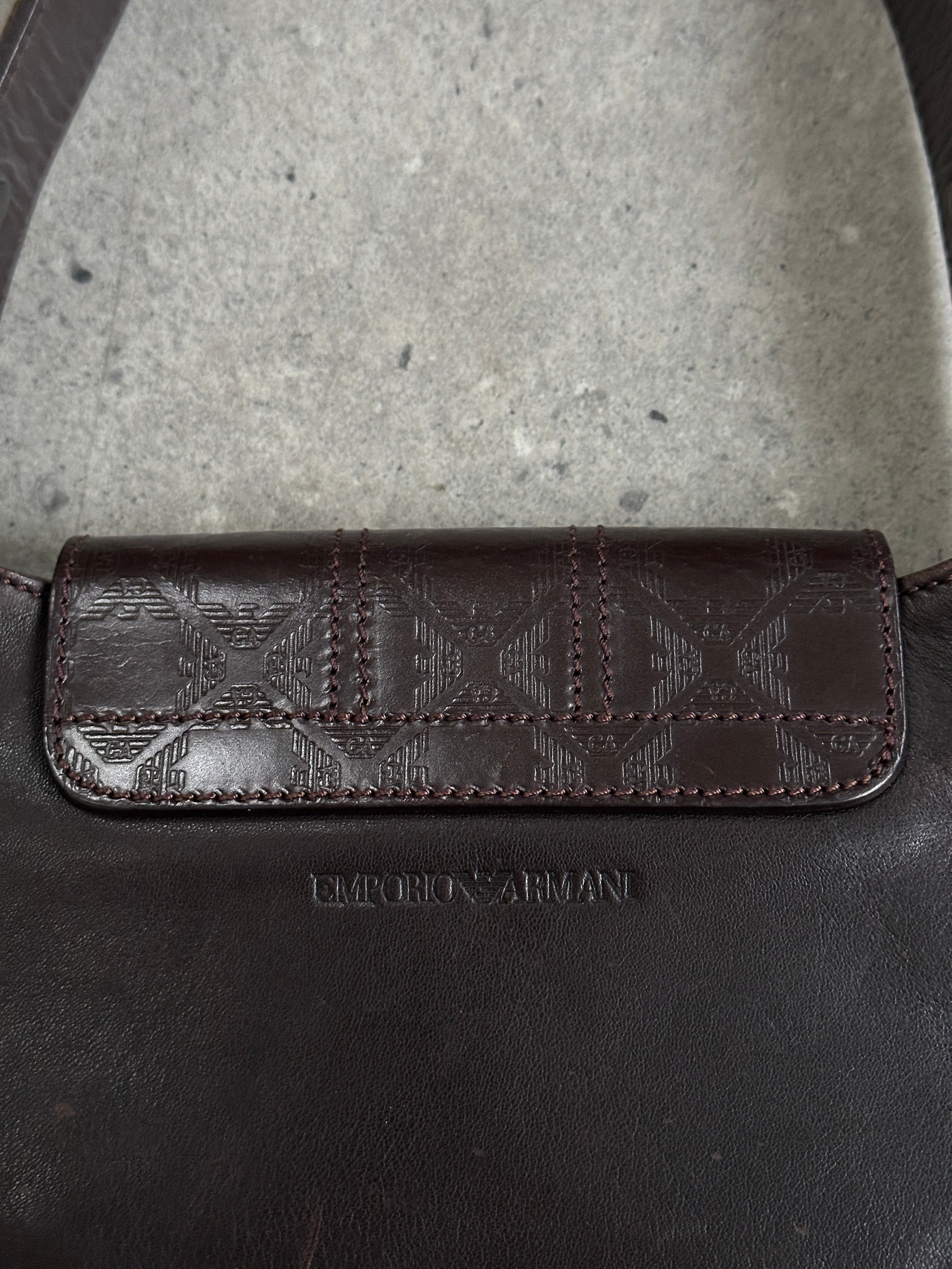 Emporio Armani leather shoulder bag with hardware monogram design, featuring sleek straps and polished details.