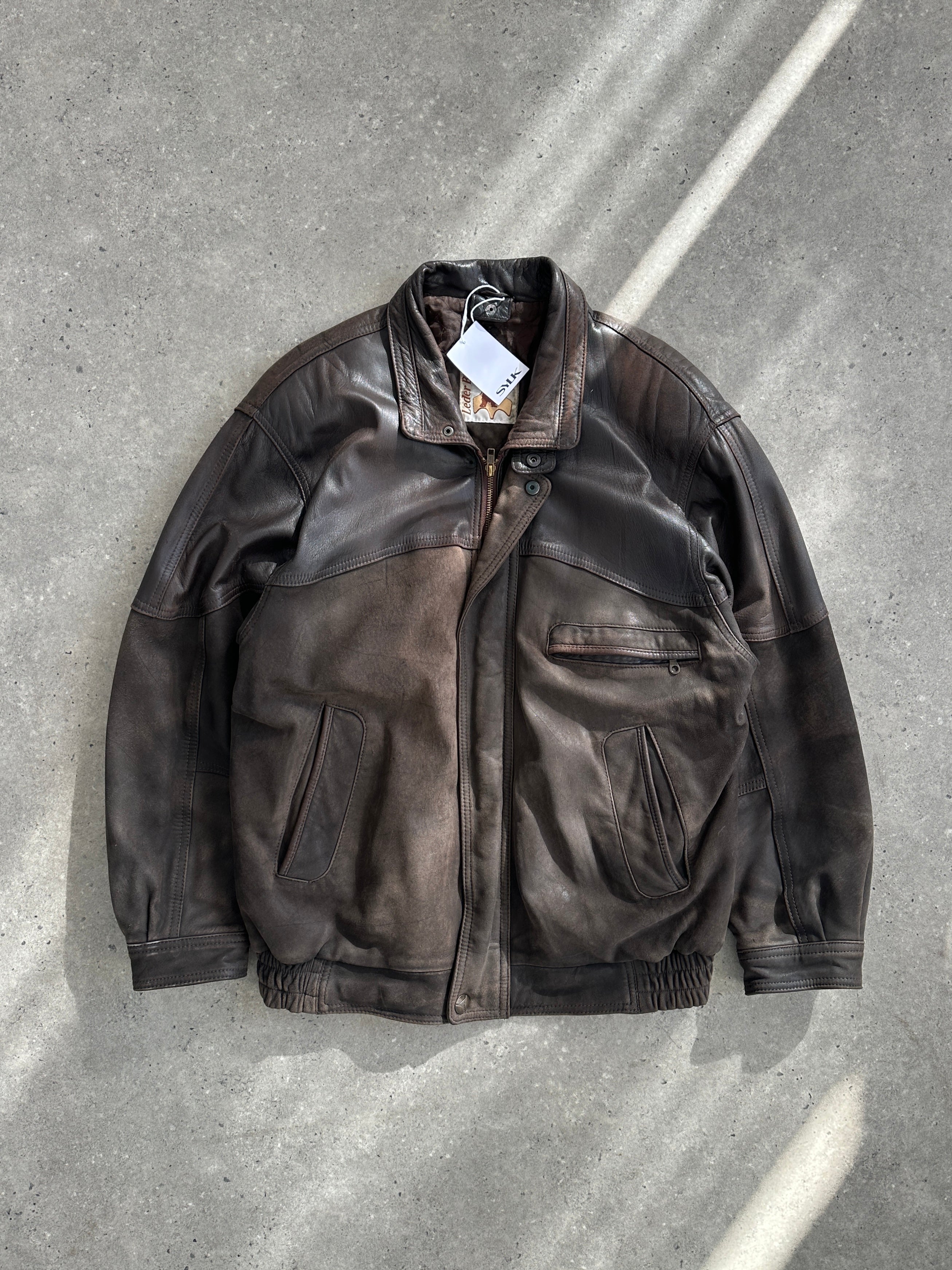 Vintage aged leather bomber jacket, size large, featuring a classic collar, front zipper, and distressed leather texture.
