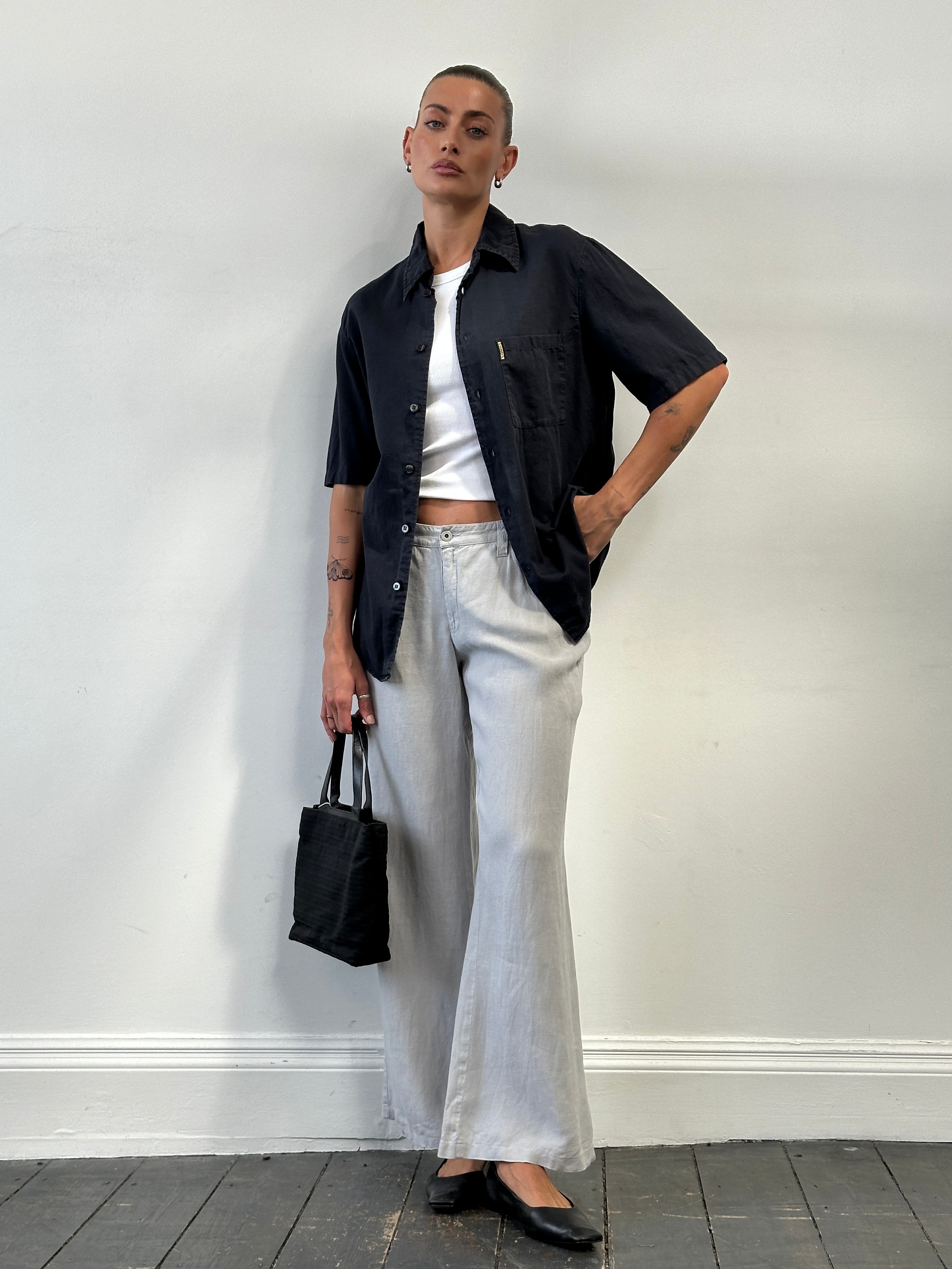 Armani Jeans pure linen flared trousers in size W33 displayed on a hanger, showing the lightweight fabric and stylish fit.