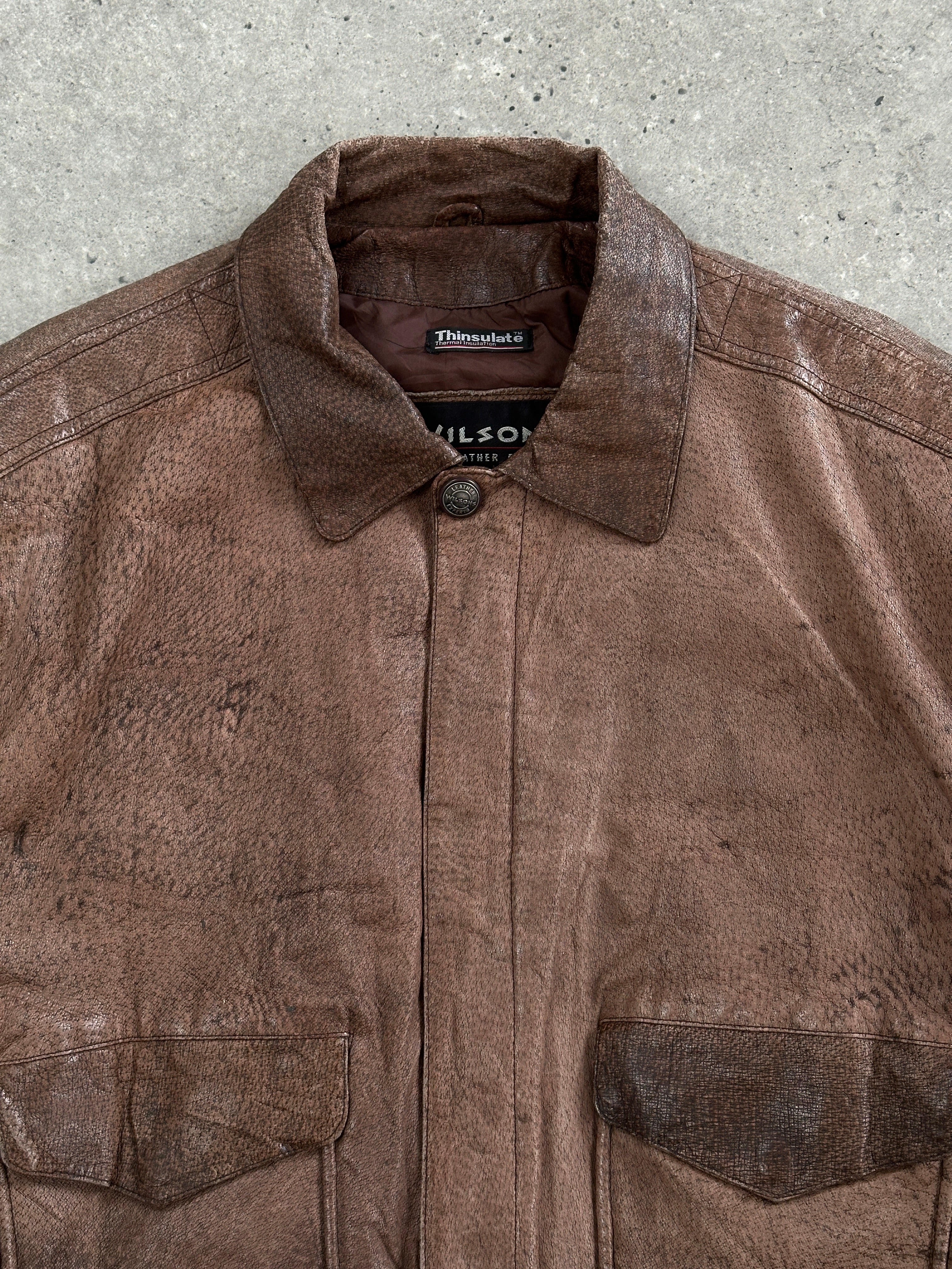 Vintage 1990s leather bomber jacket in size L, featuring classic design with a smooth brown leather finish and ribbed collar.