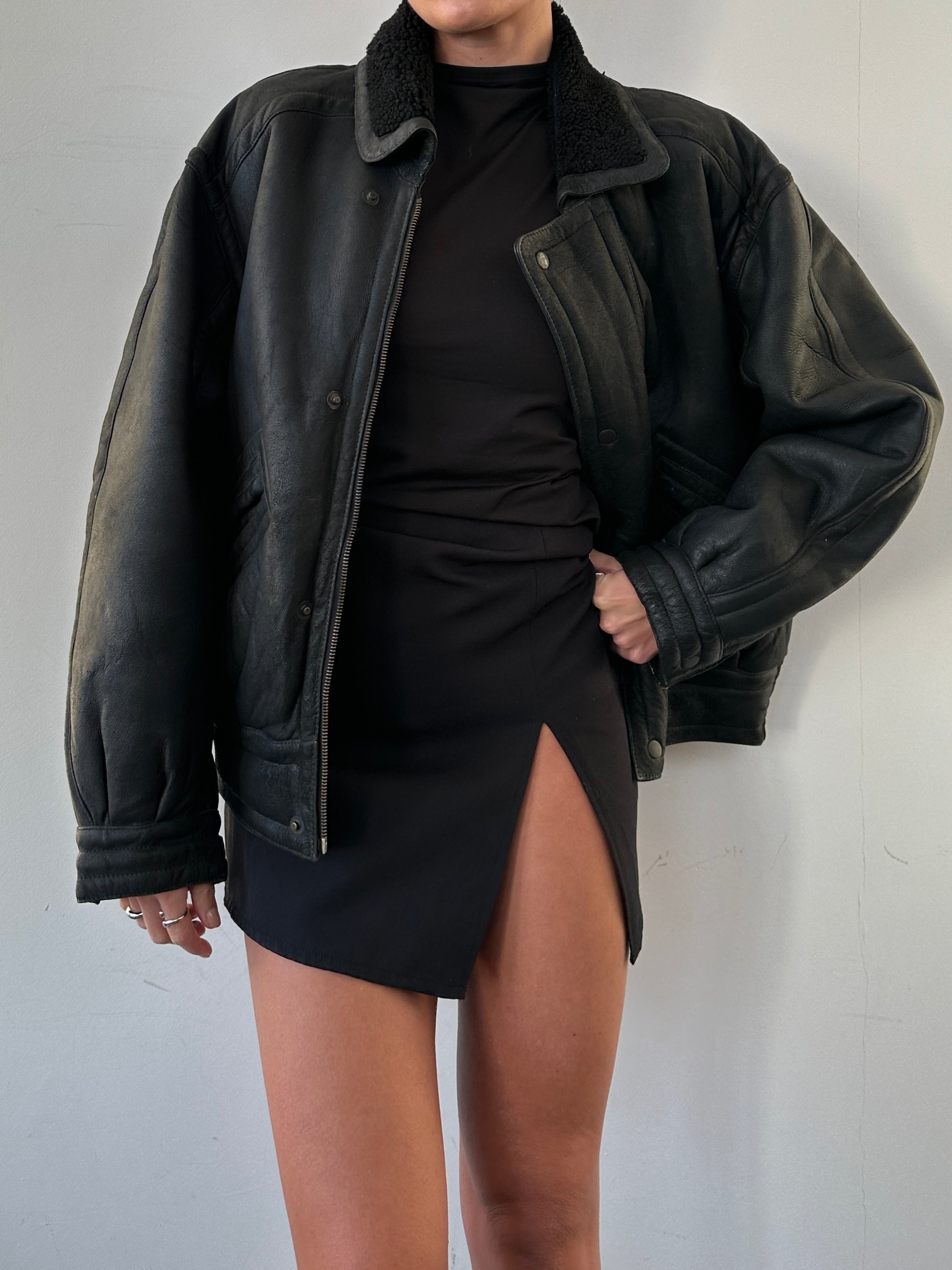 Vintage shearling leather jacket in M/L size, featuring classic design with warm shearling lining and rugged leather exterior.
