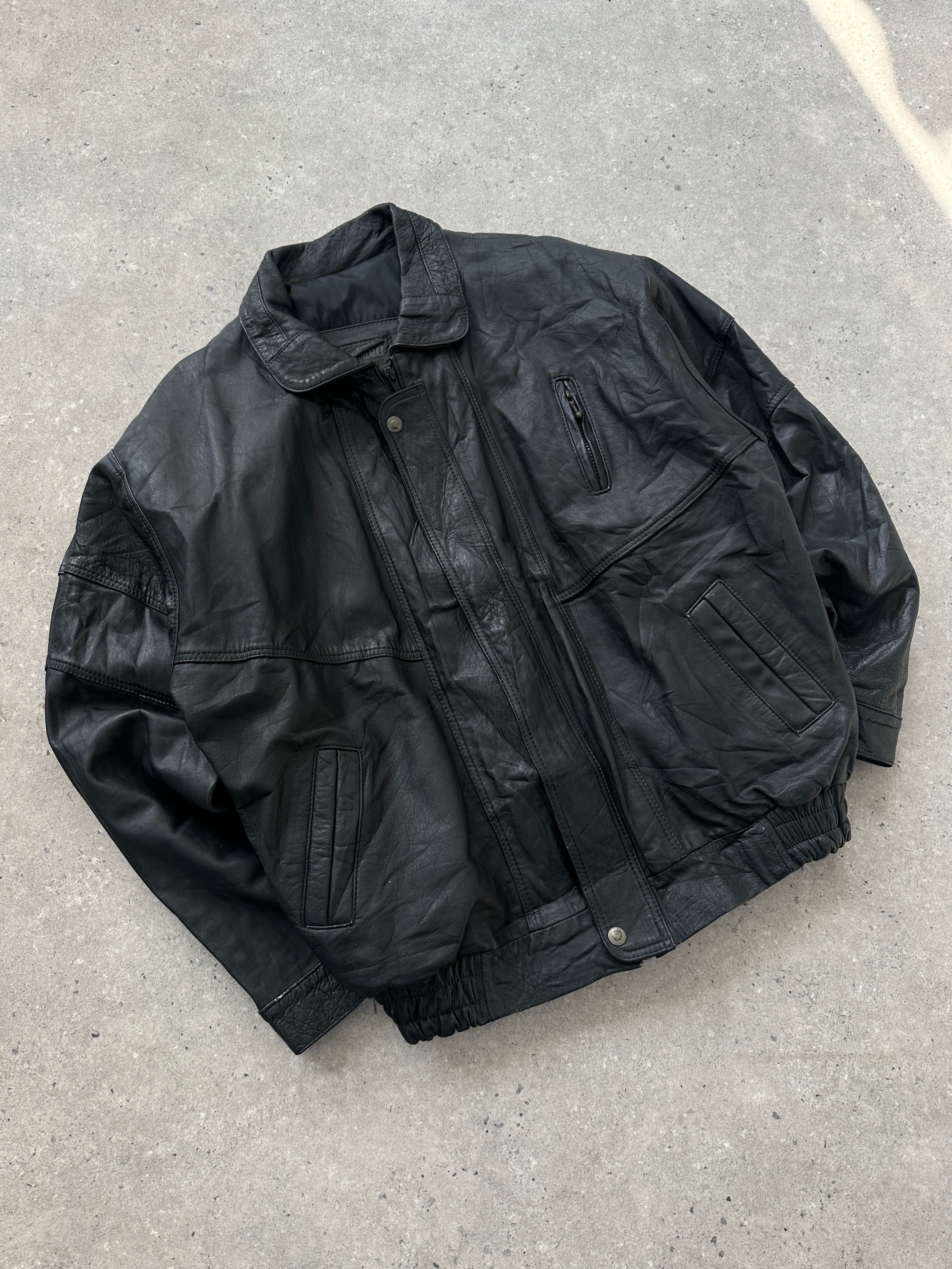 Vintage leather bomber jacket in size M/L displayed on a hanger, showcasing classic style and detailed craftsmanship.
