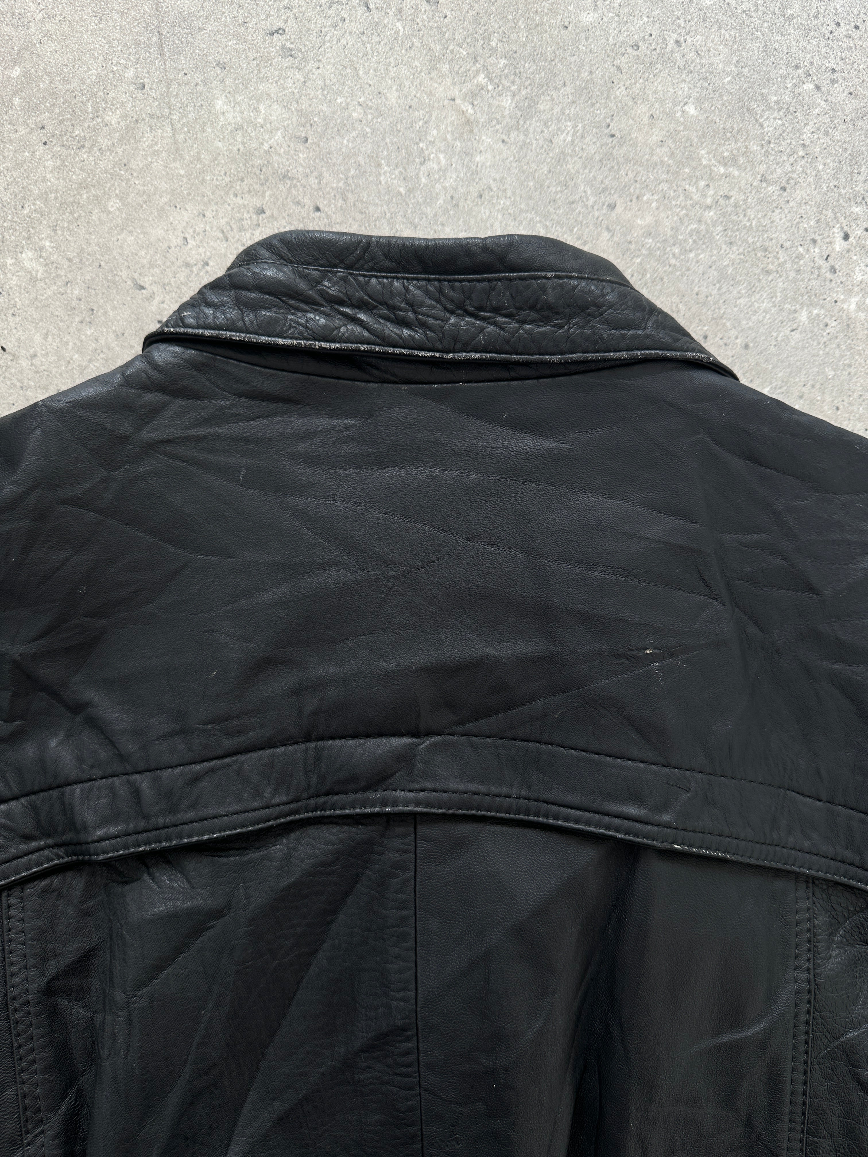Vintage leather bomber jacket in size M/L, showing classic style and textured brown leather with ribbed cuffs and collar.