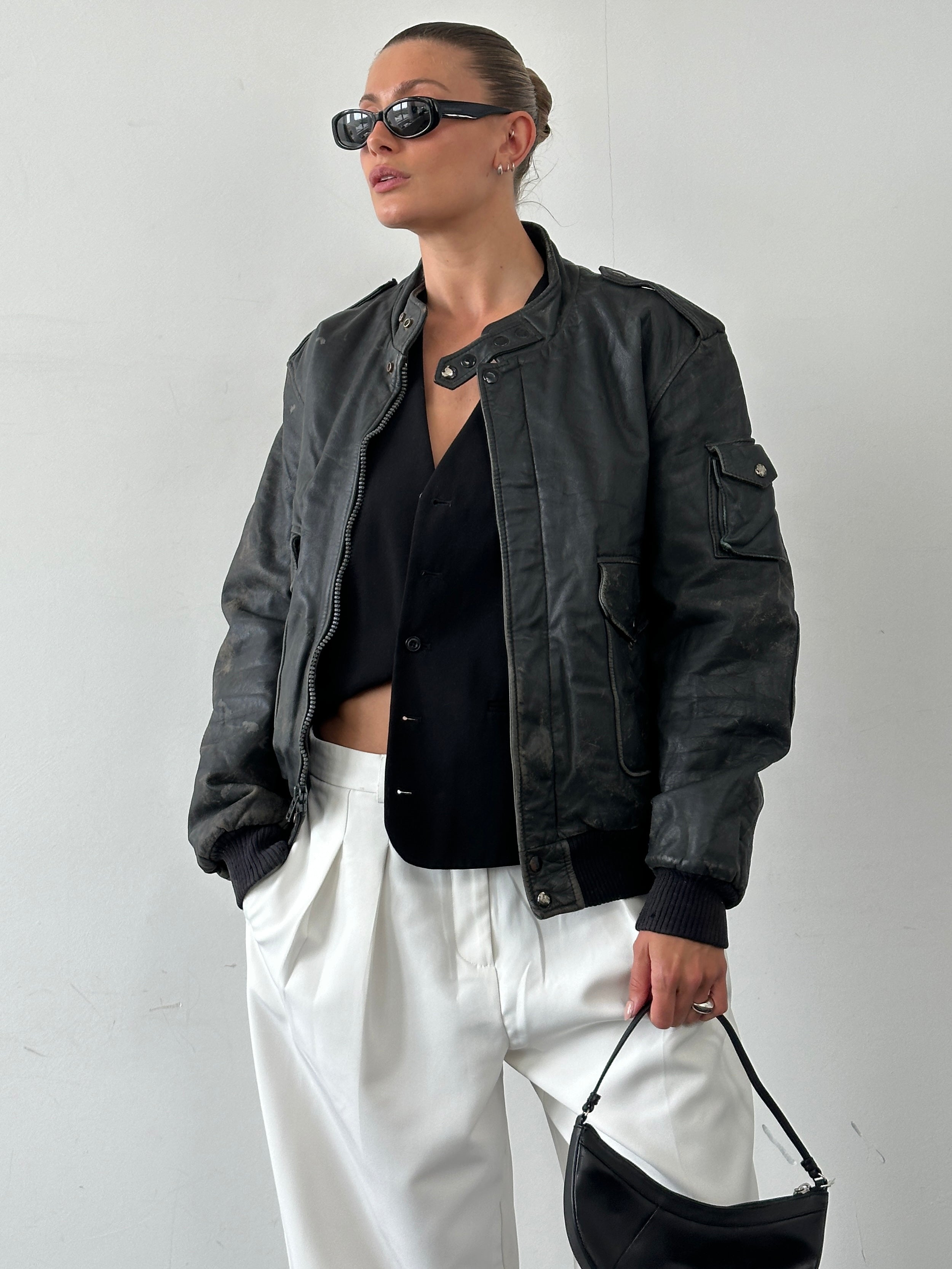 Vintage distressed leather bomber jacket in size M/L, featuring rugged, worn-in texture and classic style.