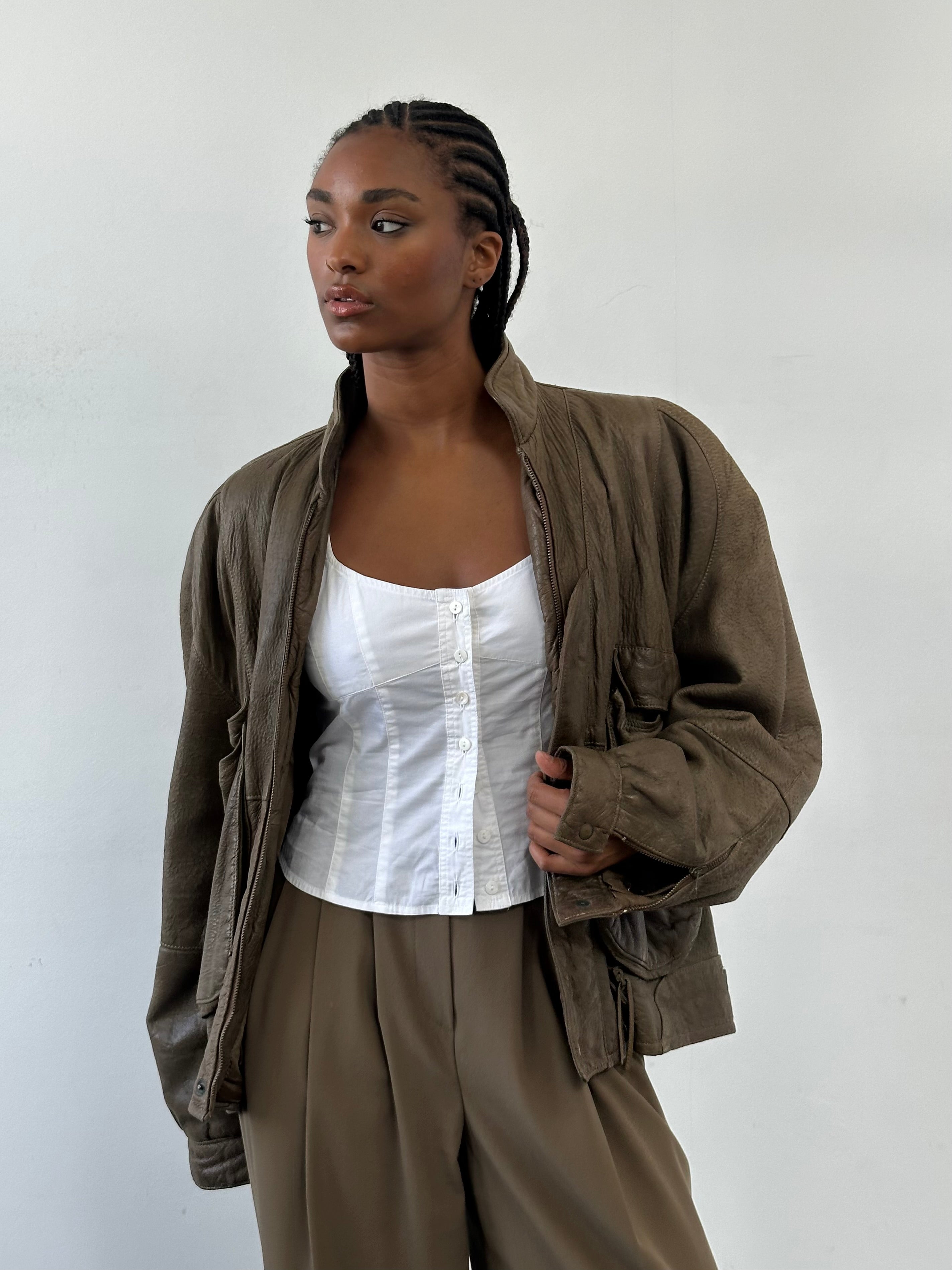 Vintage 1980s leather moto jacket in size large, featuring classic design and distressed leather with front zip and collar details.