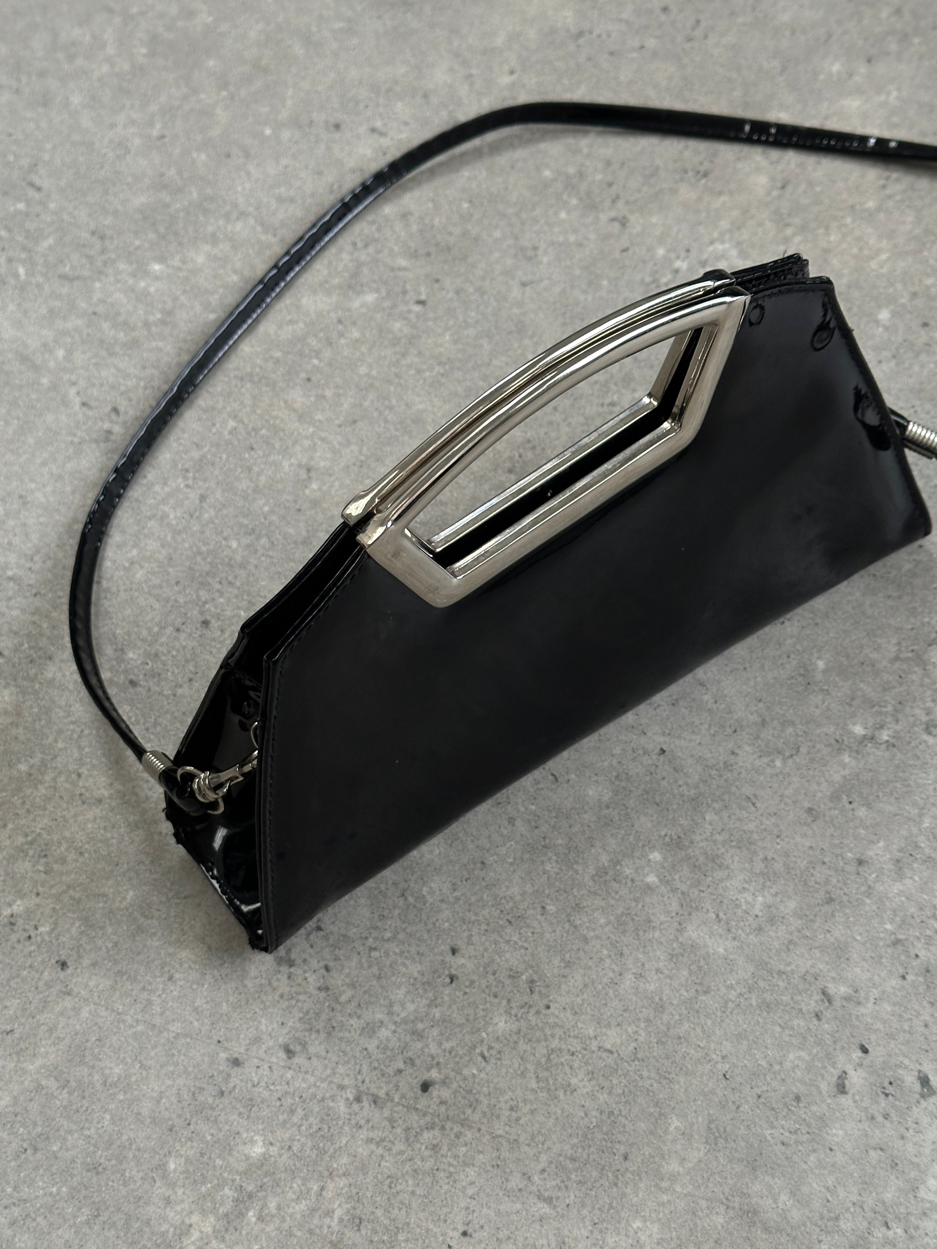Vintage 2000s patent vinyl chrome crossbody clutch bag with sleek design and shiny finish, showcasing a stylish accessory.