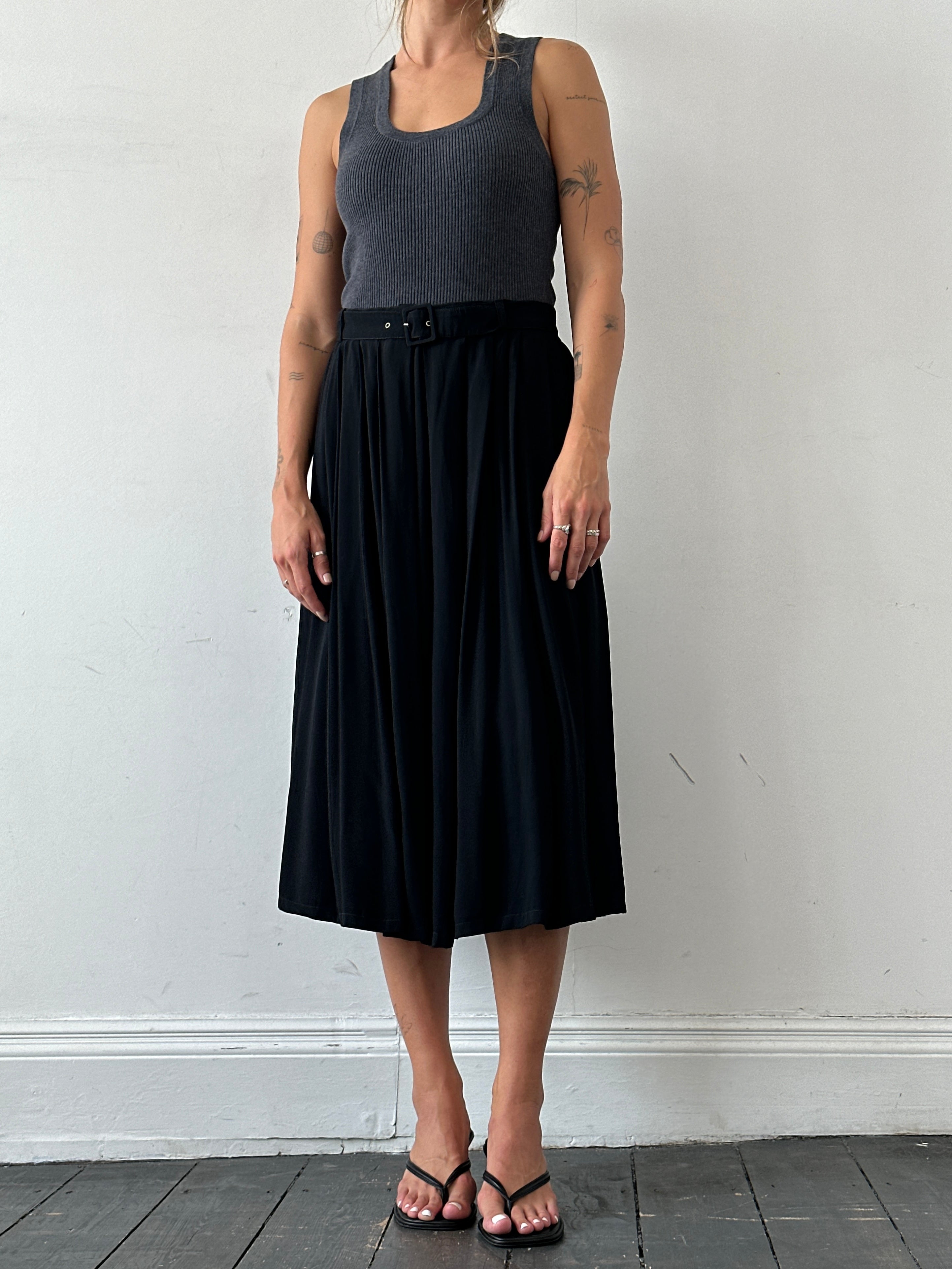 Iceberg pleated midi skirt with belted waist, in light fabric, displayed on a hanger against a neutral background.