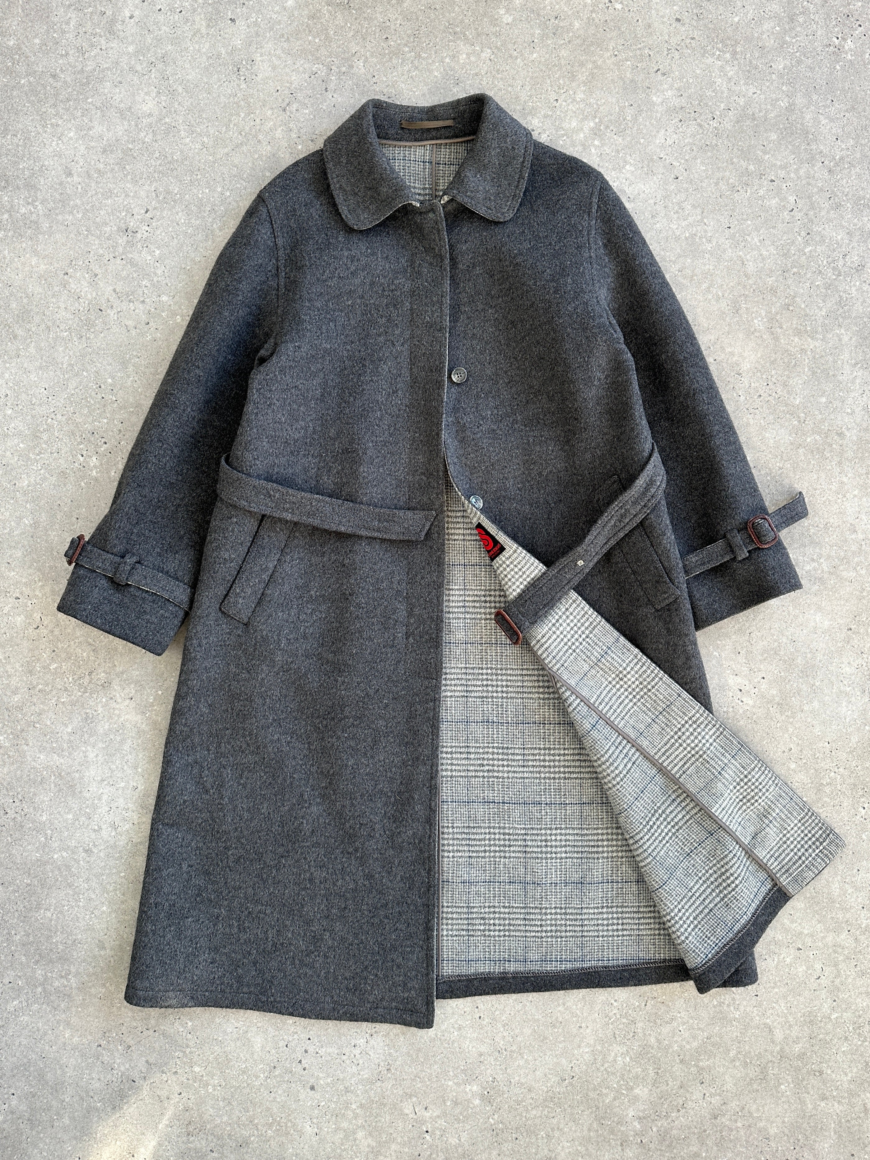 Vintage 1980s wool coat with belted waist and concealed placket, in classic style, shown on a hanger.