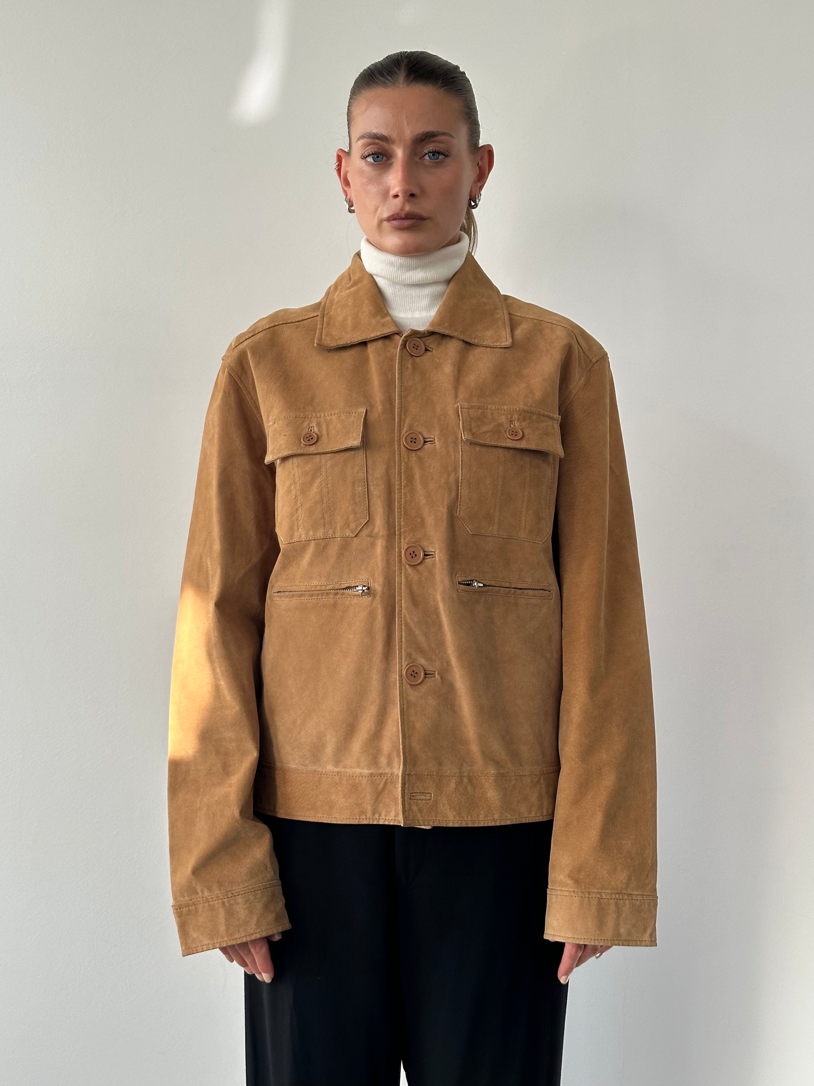 Vintage suede trucker jacket in size M/L, featuring classic design and rugged texture, displayed on a hanger.