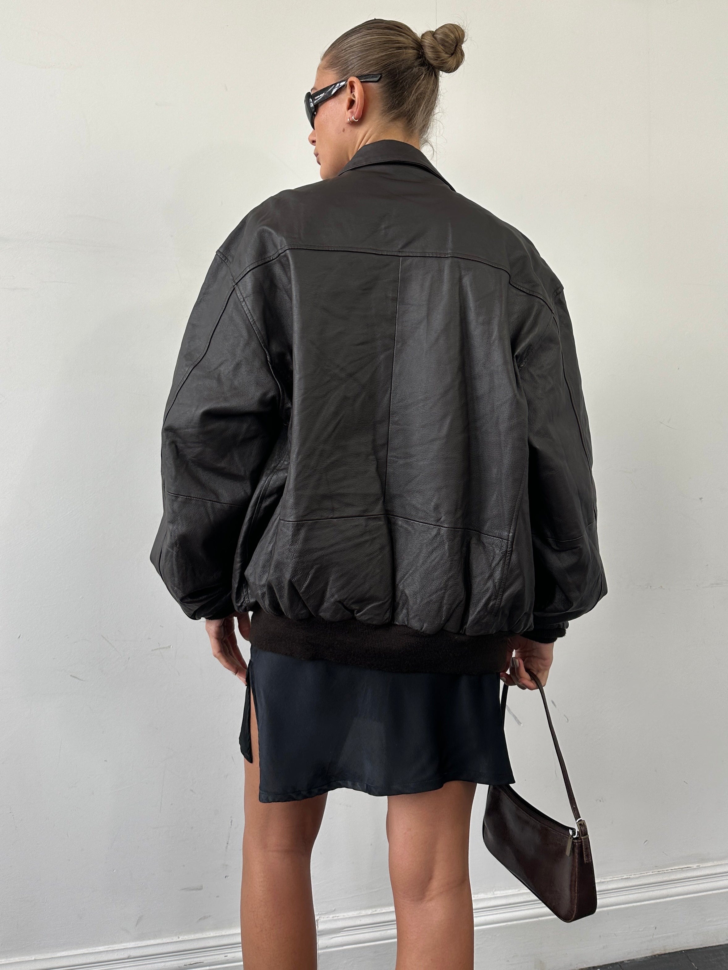 Vintage leather bomber jacket in XL size, featuring classic design with a rugged leather exterior and detailed stitching.