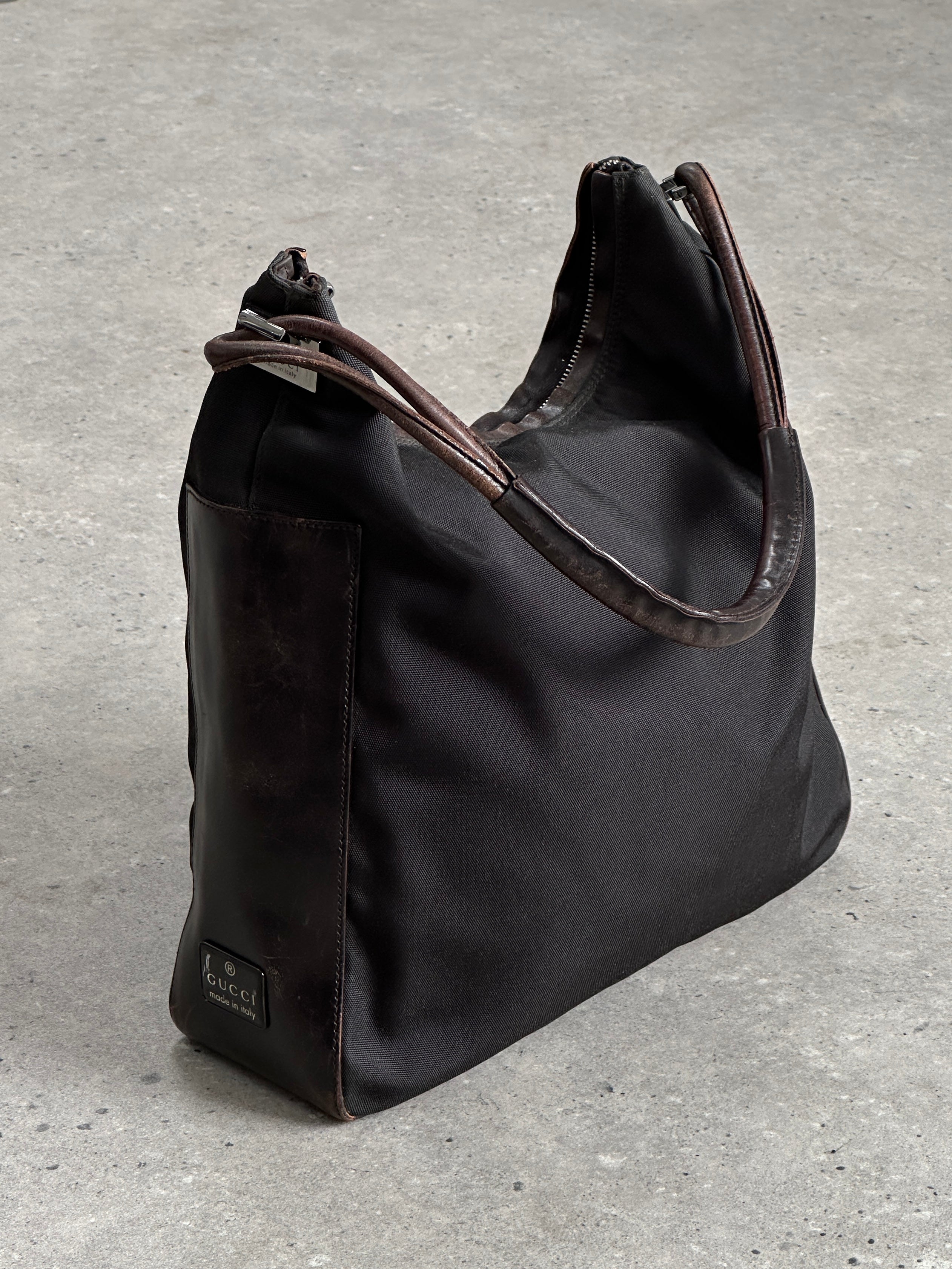 Gucci canvas and leather shoulder bag with adjustable strap and signature logo detail, stylish accessory for everyday use.
