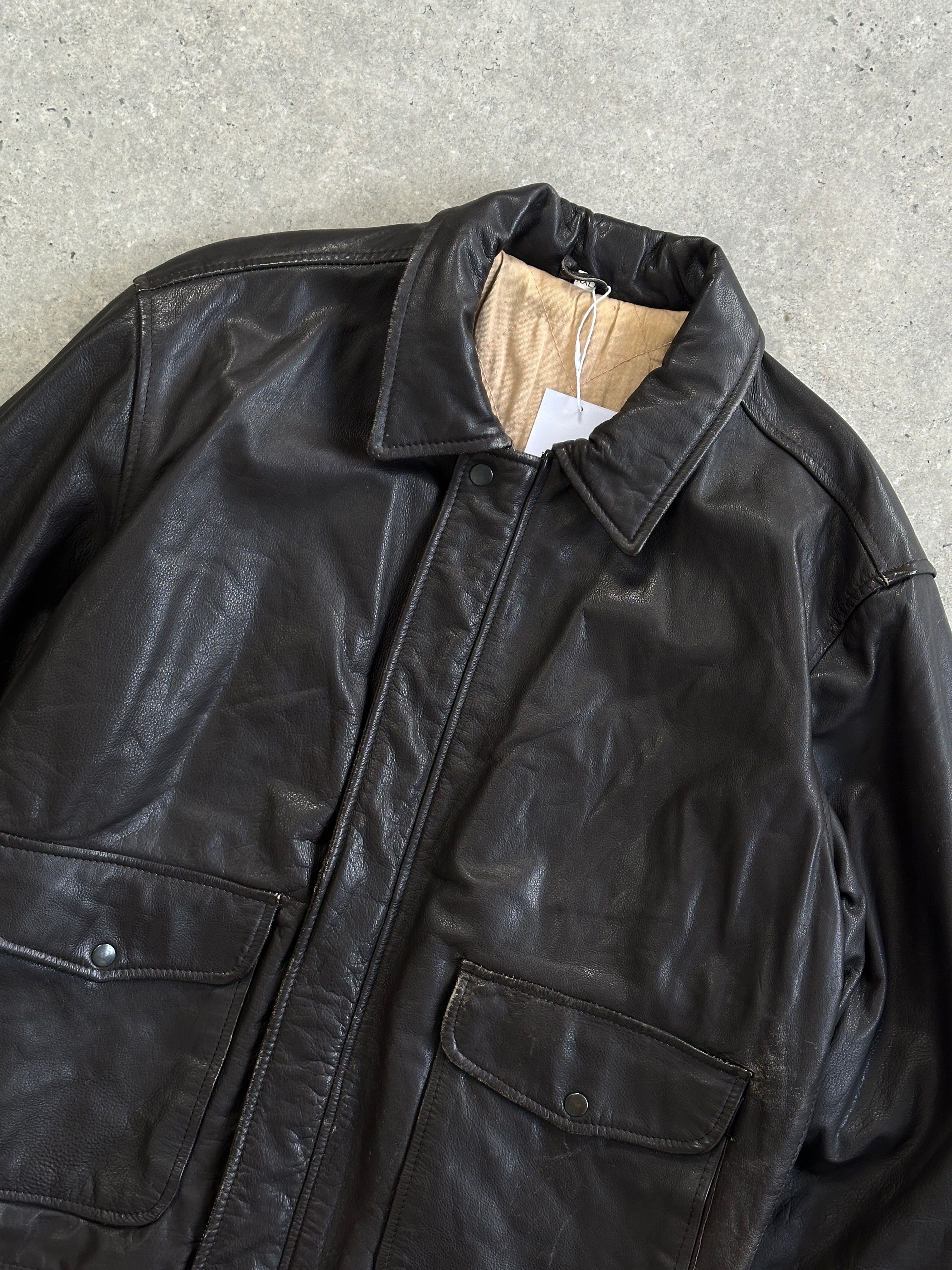 Vintage minimal zip-up leather jacket in XL, featuring a sleek design and classic brown leather, displayed on a hanger.