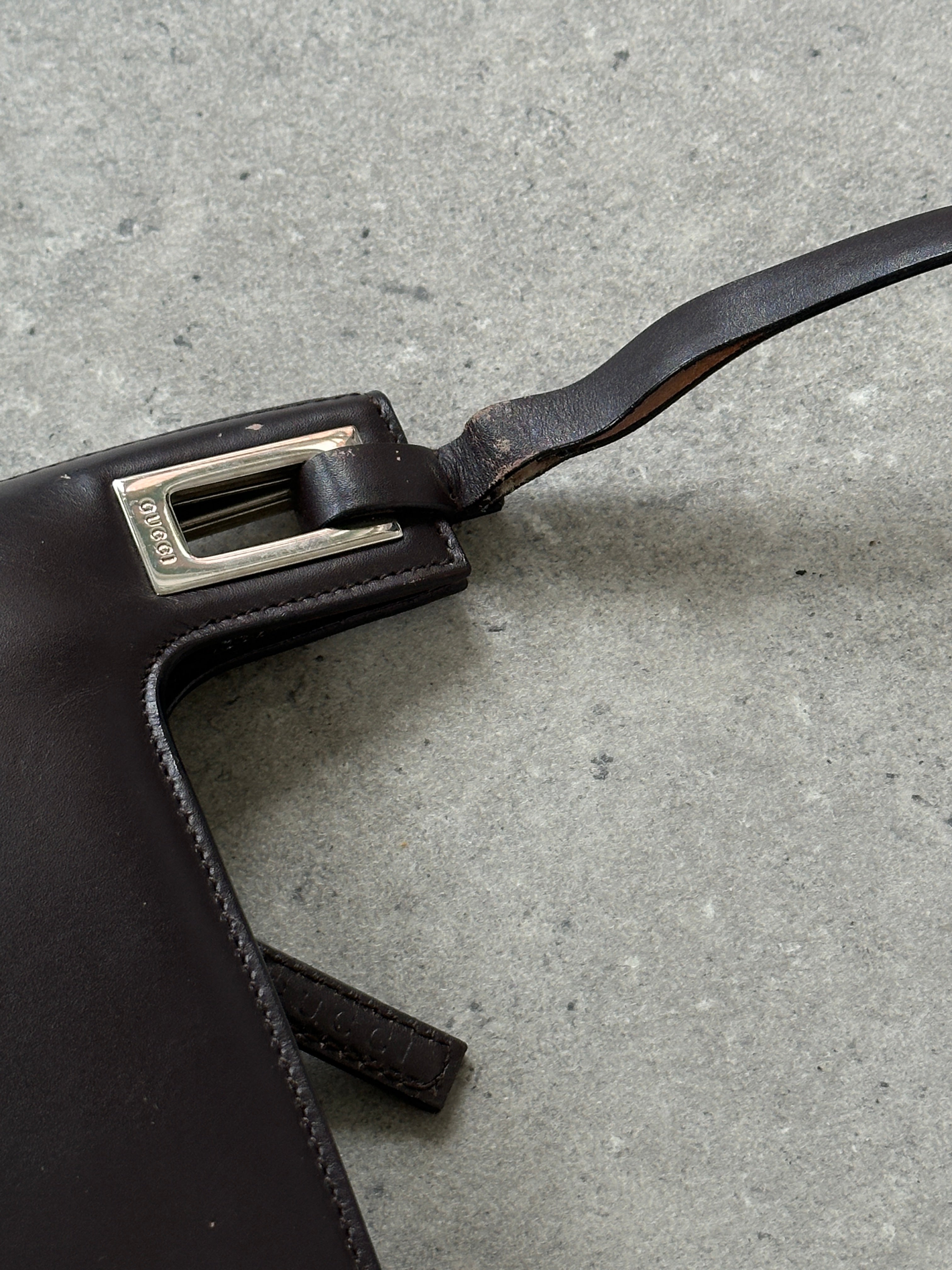 Gucci leather shoulder bag featuring a sleek design with adjustable strap and signature Gucci logo detail.